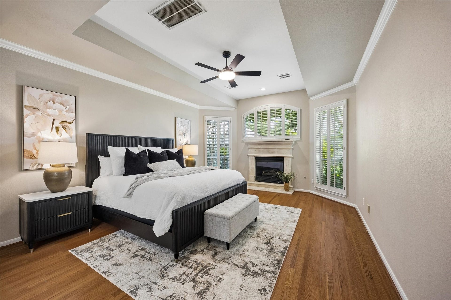 7535 Guinevere Drive, Sugar Land, TX 77479 The expansive primary suite offers a peaceful retreat with a private fireplace and tranquil backyard views. Updated fan, plantation shutters, fresh paint, and wood flooring