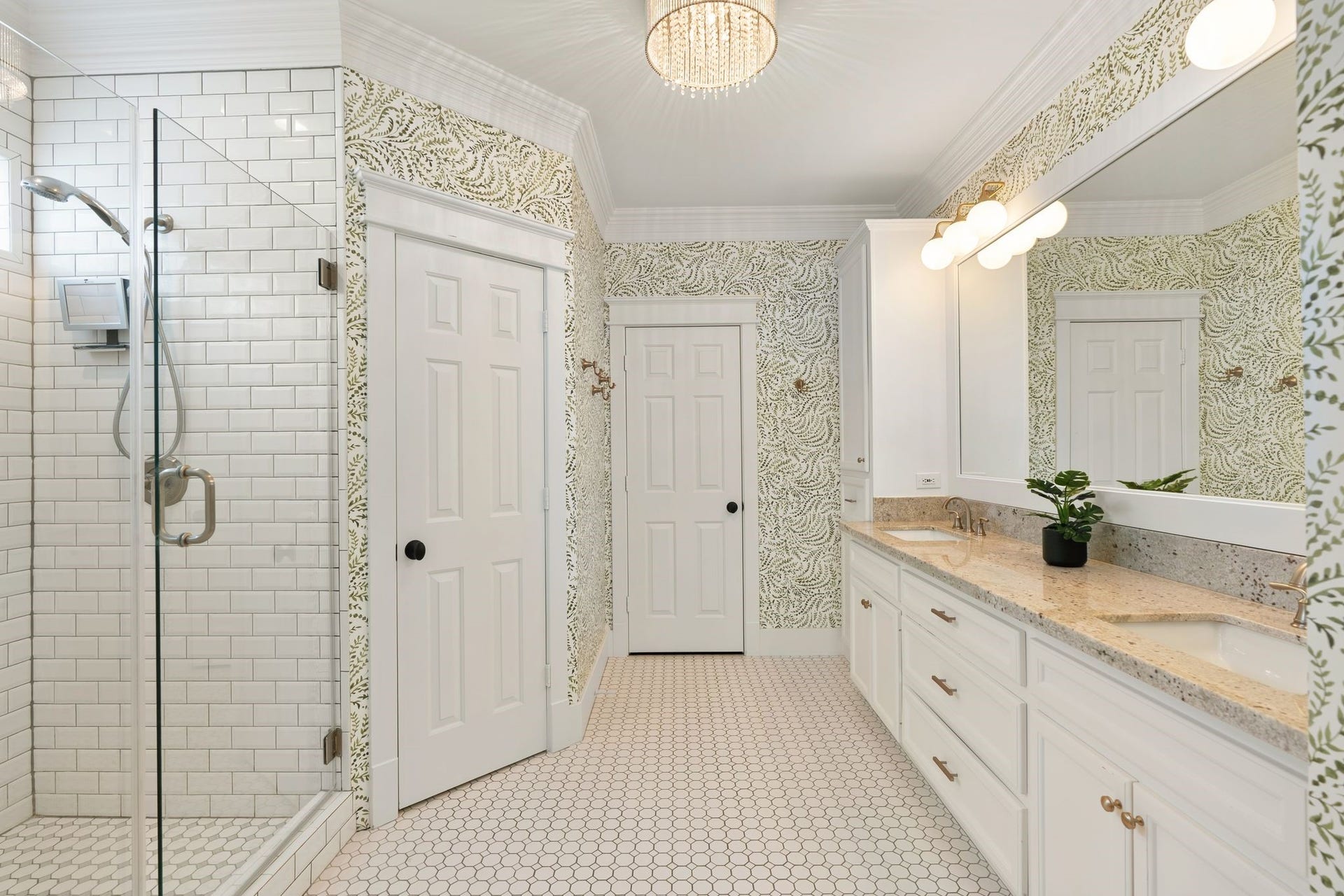 919 Ashland Street, #A, Houston, TX 77008 Gorgeous primary bath remodeled 16 w/ large dual-sink vanity, granite countertops, hex tile flooring + Serena & Lily wallpaper added 23. Frameless walk-in shower w/ bench seating, white subway tile, soap niche + privacy window. Separate water closet. New vanity lighting + decorative chandelier complete this beautifully updated space.