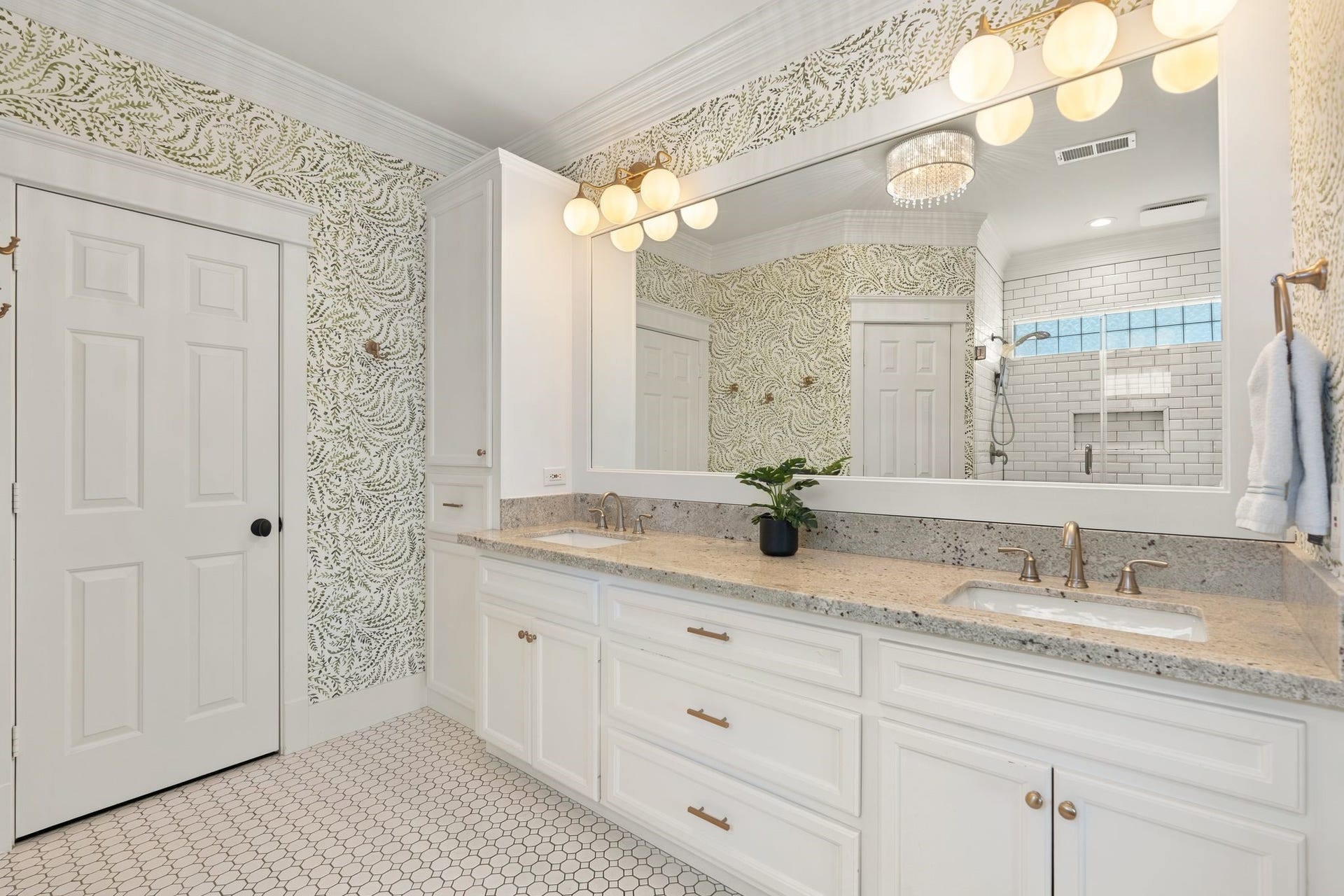 919 Ashland Street, #A, Houston, TX 77008 Another view of the primary bath showcasing the expansive vanity. Designer Serena & Lily wallpaper! Door to the left leads to is a spacious walk-in closet w/ built-in shelving, drawers & hanging space for ample storage!