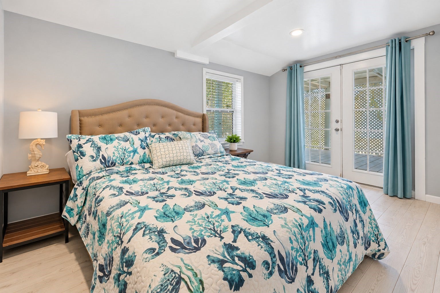 1805 19th Street, Galveston, TX 77550 Spacious first downstairs bedroom featuring coastal-inspired dcor, abundant natural light, and French doors providing direct access to the covered outdoor area.