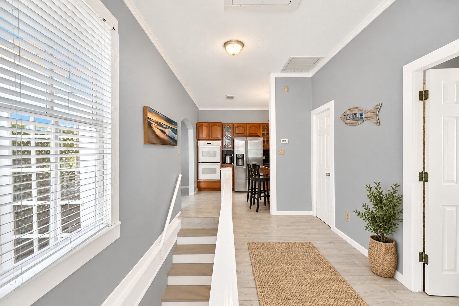 1805 19th Street, Galveston, TX 77550 Bright and inviting stairwell leading to the second-floor hallway that features natural light, and coastal-inspired finishes. Conveniently connects the upstairs kitchen, dining, and living areas, while the staircase also provides access to the first-floor entry and two downstairs bedrooms with a shared Jack-and-Jill bathroom. A practical two-level layout designed for comfortable coastal living.