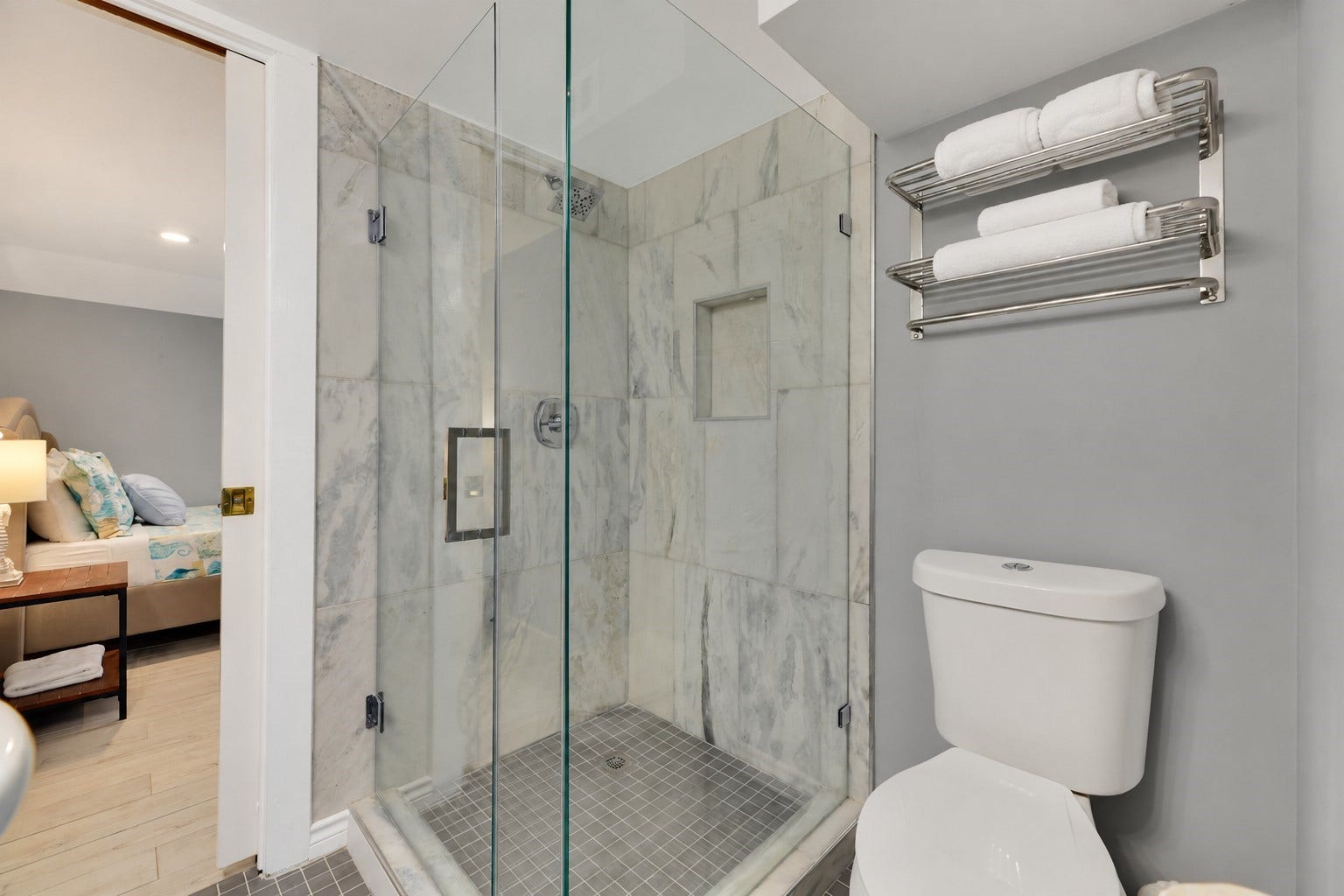 1805 19th Street, Galveston, TX 77550 Beautifully appointed Jack-and-Jill bathroom connecting Bedrooms 1 and 2 on the first floor. Features a spacious walk-in shower with marble-look tile surround, frameless glass enclosure, rainfall-style showerhead, built-in shower niche, and modern finishes.