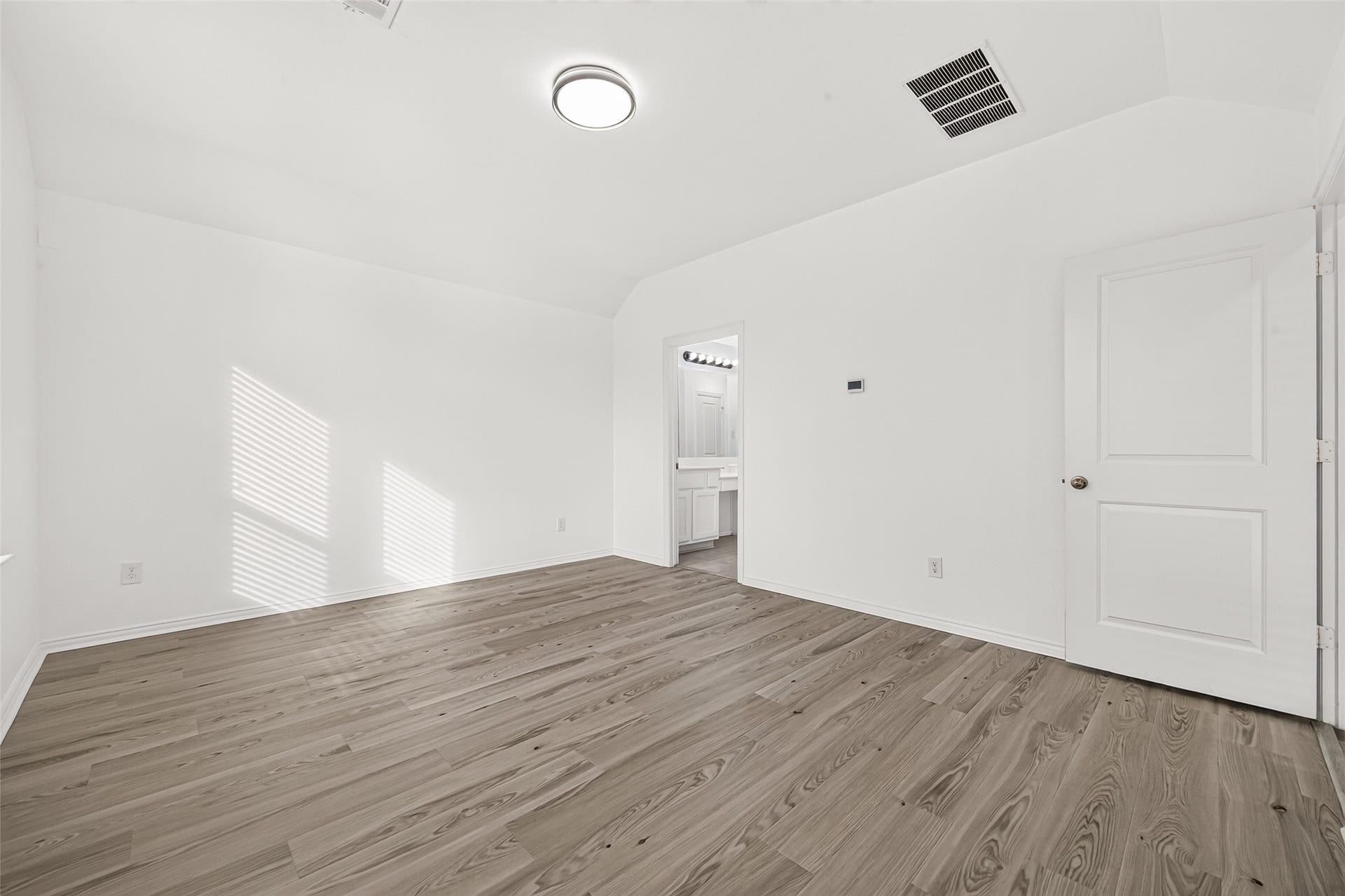 19711 Lakeside Pointe, Richmond, TX 77407 Retreat to this spacious primary bedroom featuring high ceilings, natural light, and warm wood-look flooring. A neutral palette and direct access to the ensuite bathroom create a comfortable space to unwind