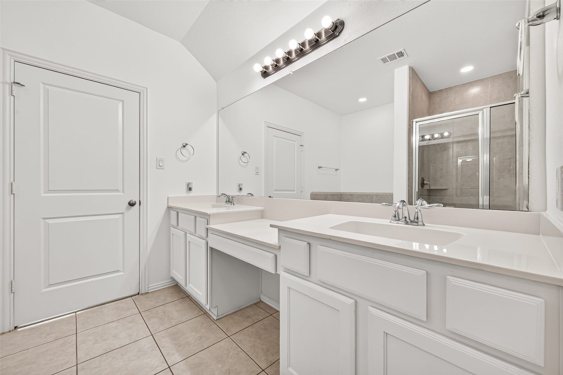 19711 Lakeside Pointe, Richmond, TX 77407 Start your day in this bright primary bathroom featuring dual sinks, a dedicated seated vanity, generous cabinet storage, and an expansive mirror