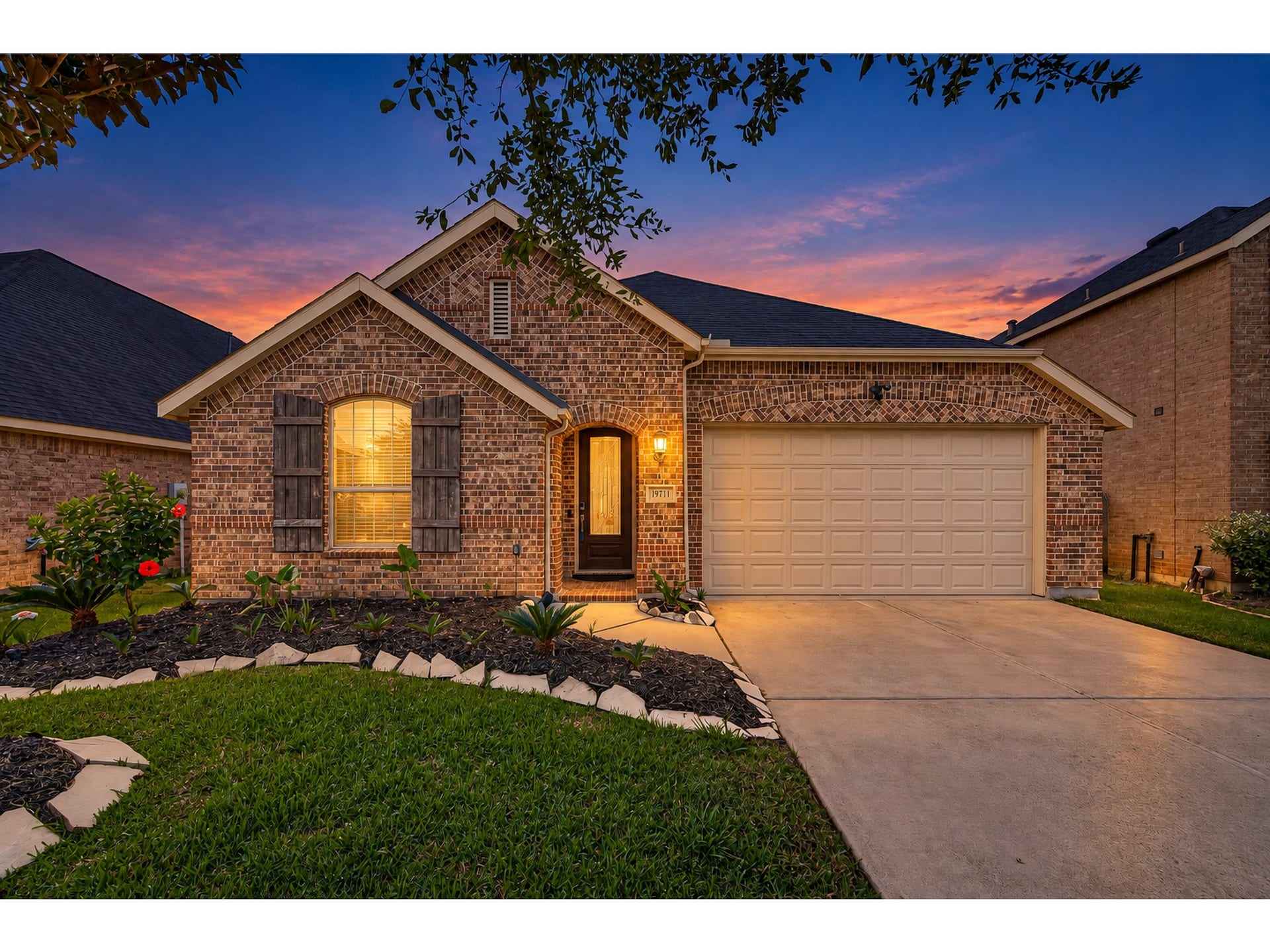19711 Lakeside Pointe, Richmond, TX 77407 Beautiful brick details and a welcoming covered entry shine against a colorful twilight sky