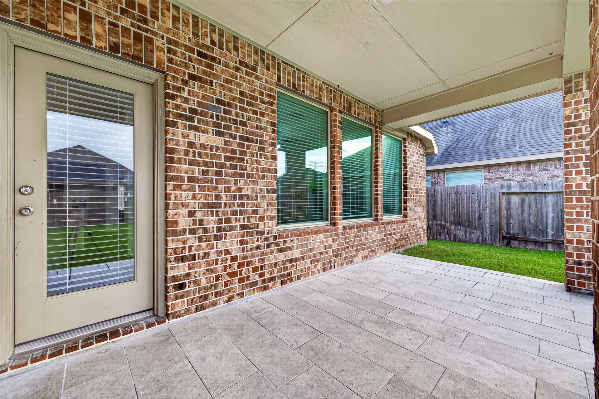 19711 Lakeside Pointe, Richmond, TX 77407 Enjoy morning coffee or unwind in the shade on this covered patio, featuring tile flooring and classic brick surroundingsready for your favorite outdoor seating