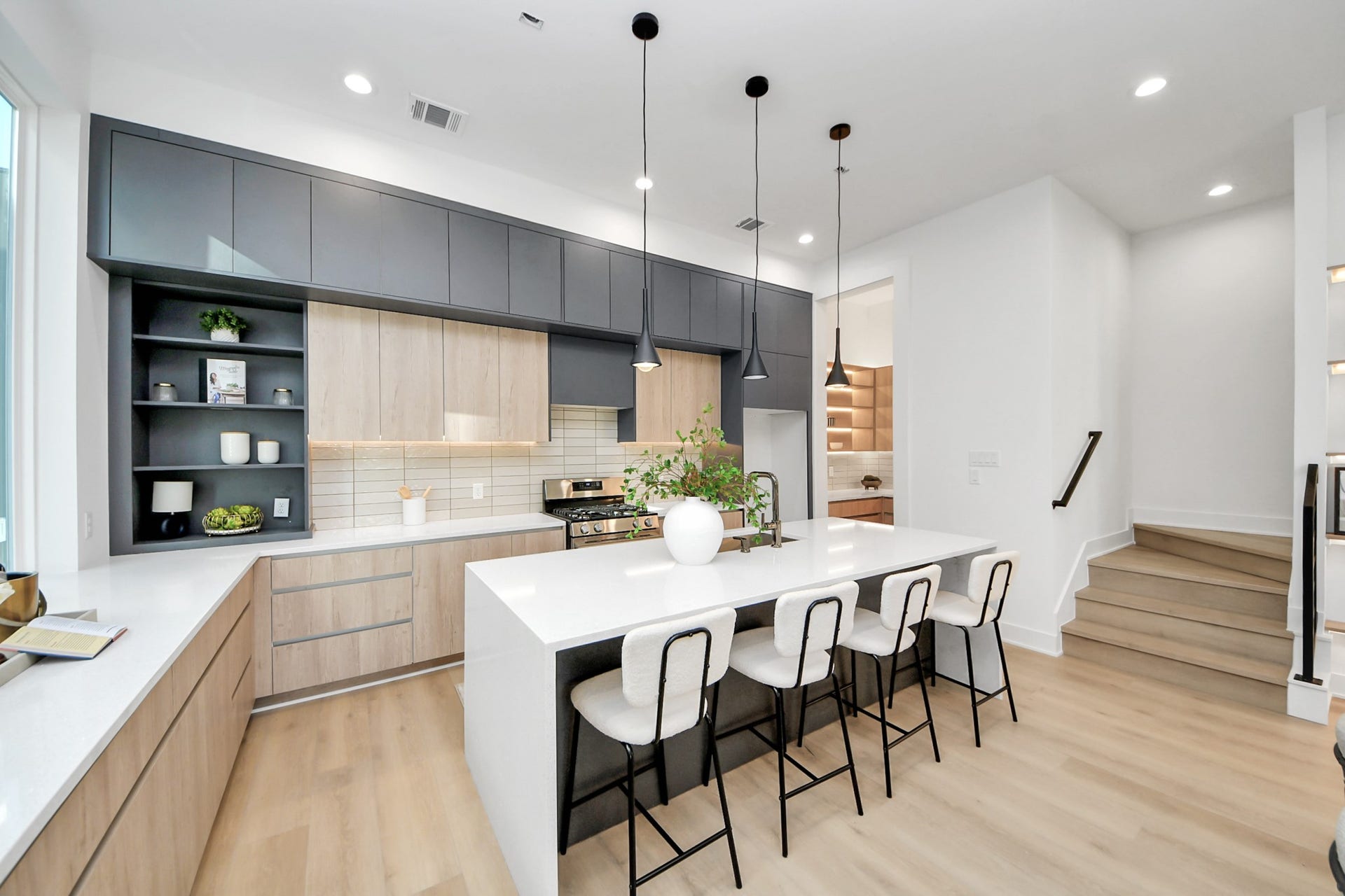 1603 W 25th Street, Houston, TX 77008 Modern kitchen featuring an oversized waterfall island with seating for four and sleek two-tone cabinetry.