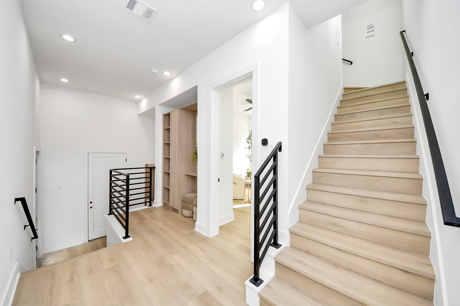1603 W 25th Street, Houston, TX 77008 Open stair landing with sleek black railings and custom built-in storage.