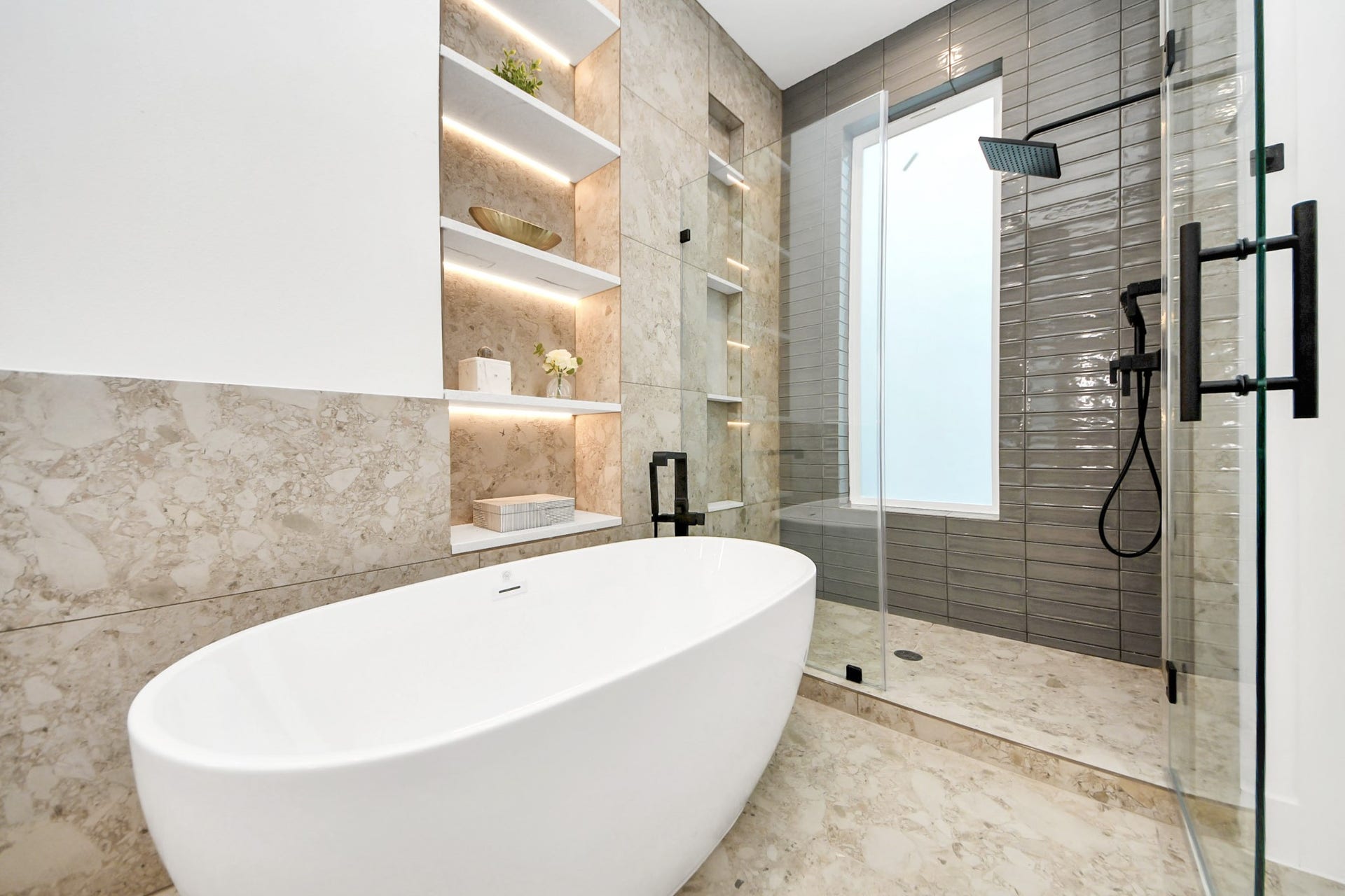 1603 W 25th Street, Houston, TX 77008 Primary bathroom featuring a freestanding tub, glass-enclosed shower, and built-in shelving.