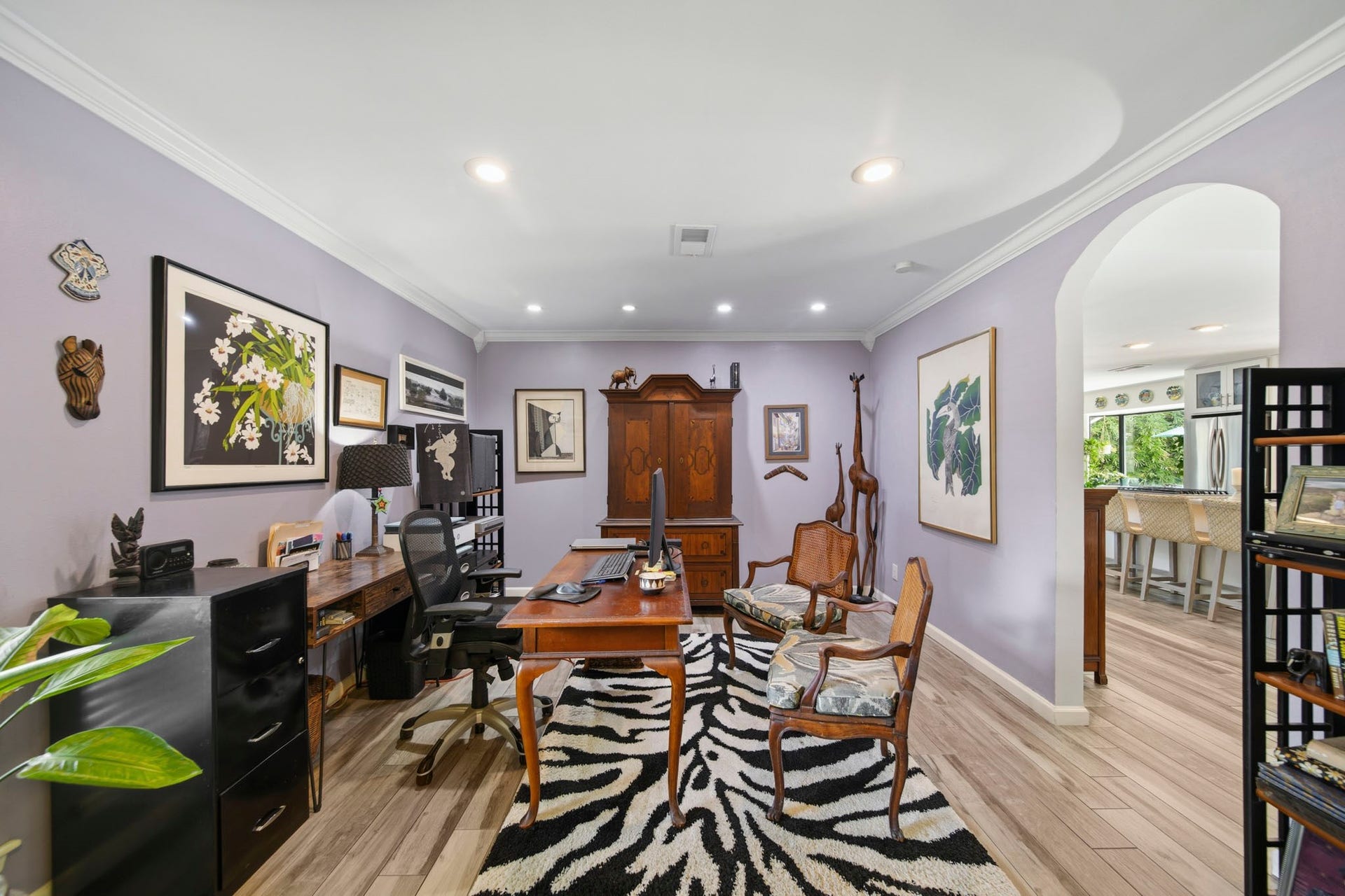 A dedicated home office with elegant crown molding and recessed lighting. Arched entry and generous wall space provide a quiet, functional workspace that can also serve as a flex room, study, or library.