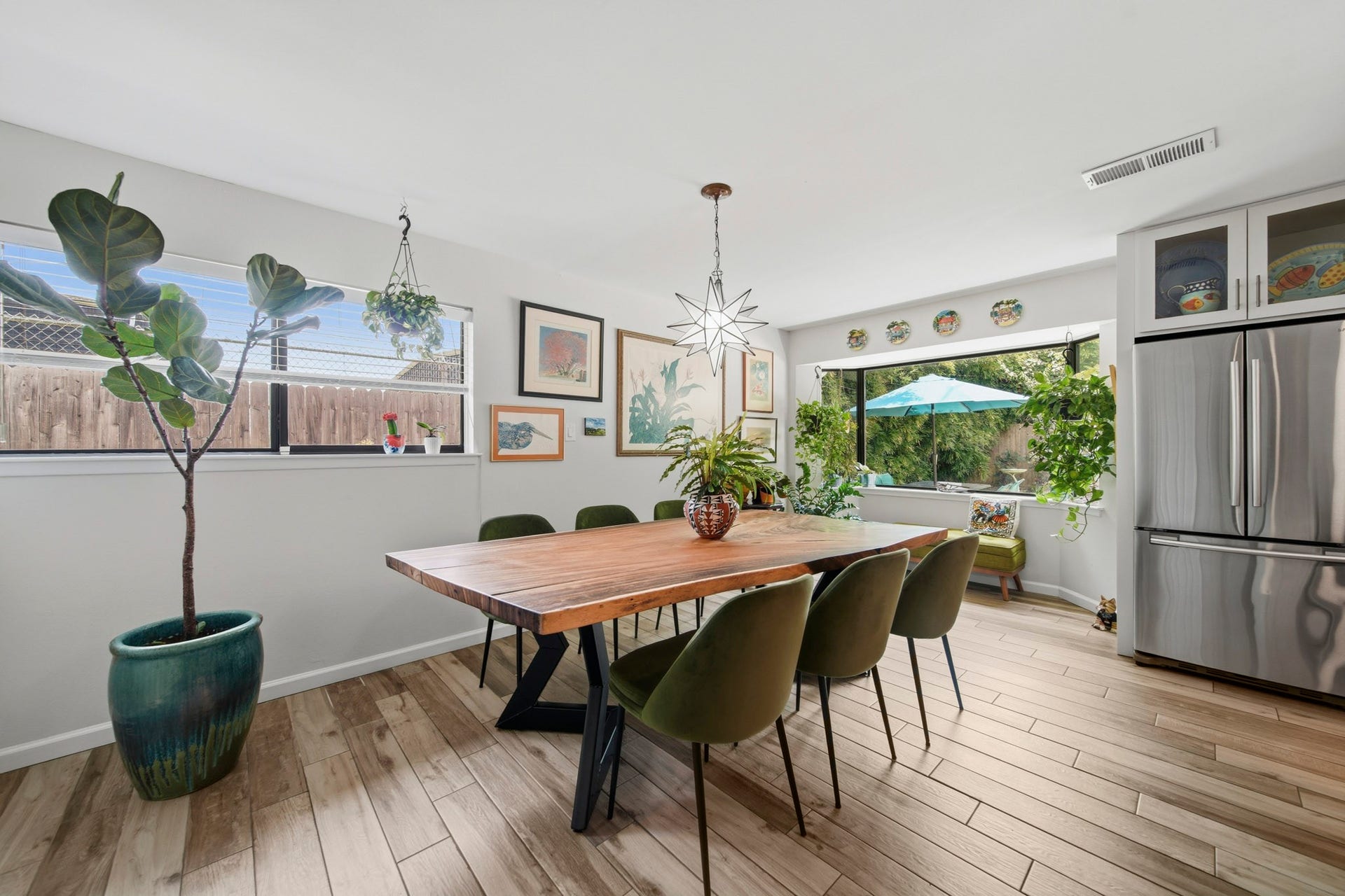 The spacious dining area is filled with natural light and offers the perfect setting for everyday meals or memorable gatherings. Large windows frame peaceful backyard and pool views, while the charming window seat creates a cozy spot to relax with a morning coffee or unwind at the end of the day.