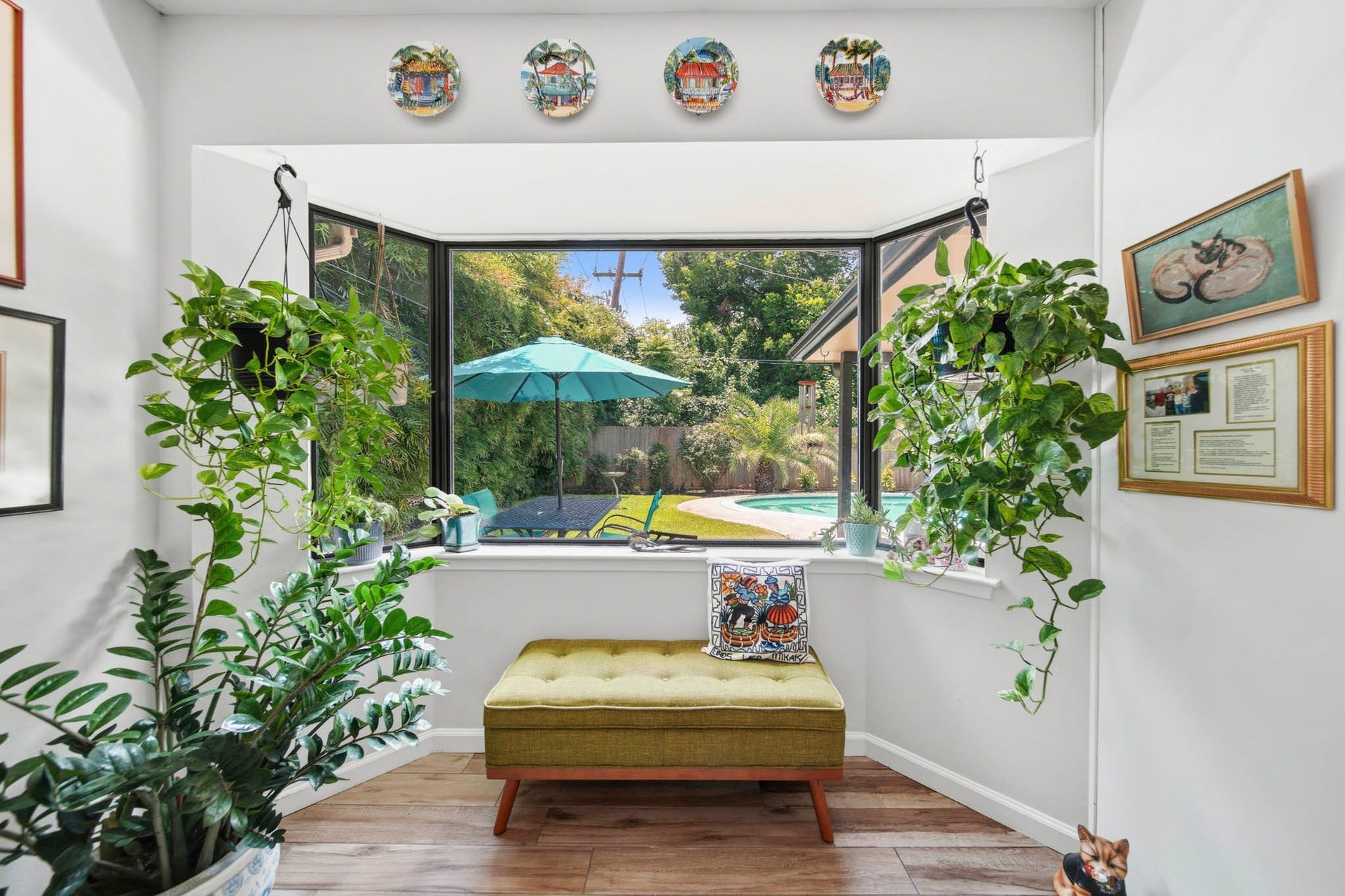 Enjoy a peaceful indoor-outdoor connection in this bright window retreat overlooking the private backyard and sparkling pool. Framed by expansive picture windows and surrounded by lush greenery, this versatile nook is the perfect place to relax with a morning coffee, read a book, or simply take in the tranquil views year-round.