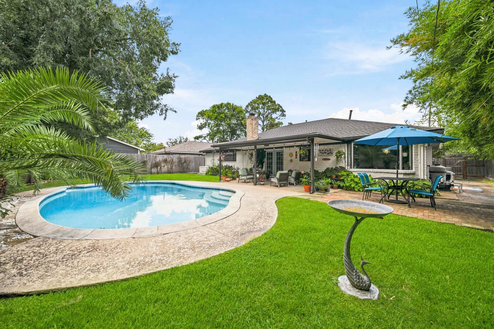 Escape to your own private backyard retreat, where a sparkling freeform pool, lush lawn, and exotic landscaping create the perfect setting for relaxation and entertaining. Multiple outdoor living areasincluding a spacious covered patio and poolside dining spaceoffer plenty of room to host guests or simply enjoy peaceful evenings in your own resort-style oasis.
