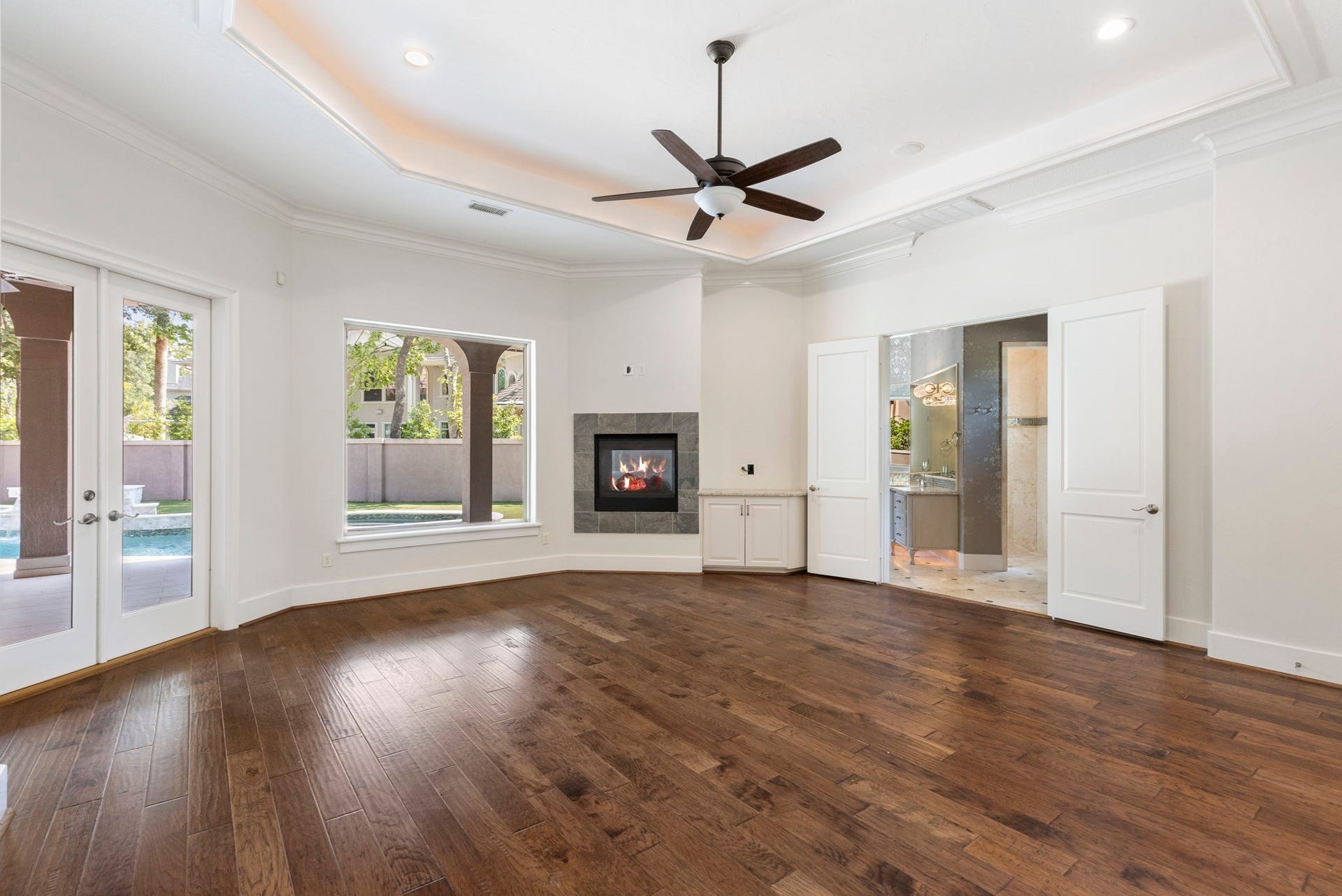 47 Hunnewell Way, The Woodlands, TX 77382 Primary Suite: highlights hand-scraped wood flooring, dual sided fireplace and inviting views.