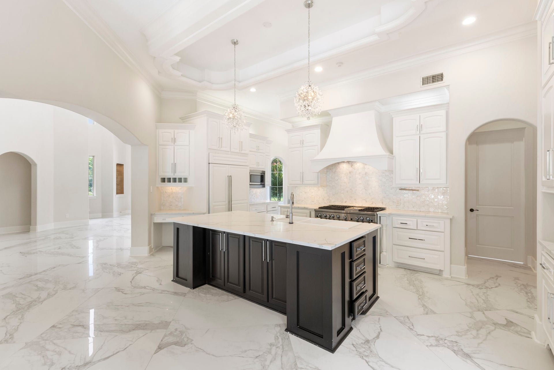 47 Hunnewell Way, The Woodlands, TX 77382 The butler's pantry area also has quick access into the kitchen area showcasing updates to include painted cabinetry, tile backsplash, countertops & reimagined island, sink, hardware and lighting.