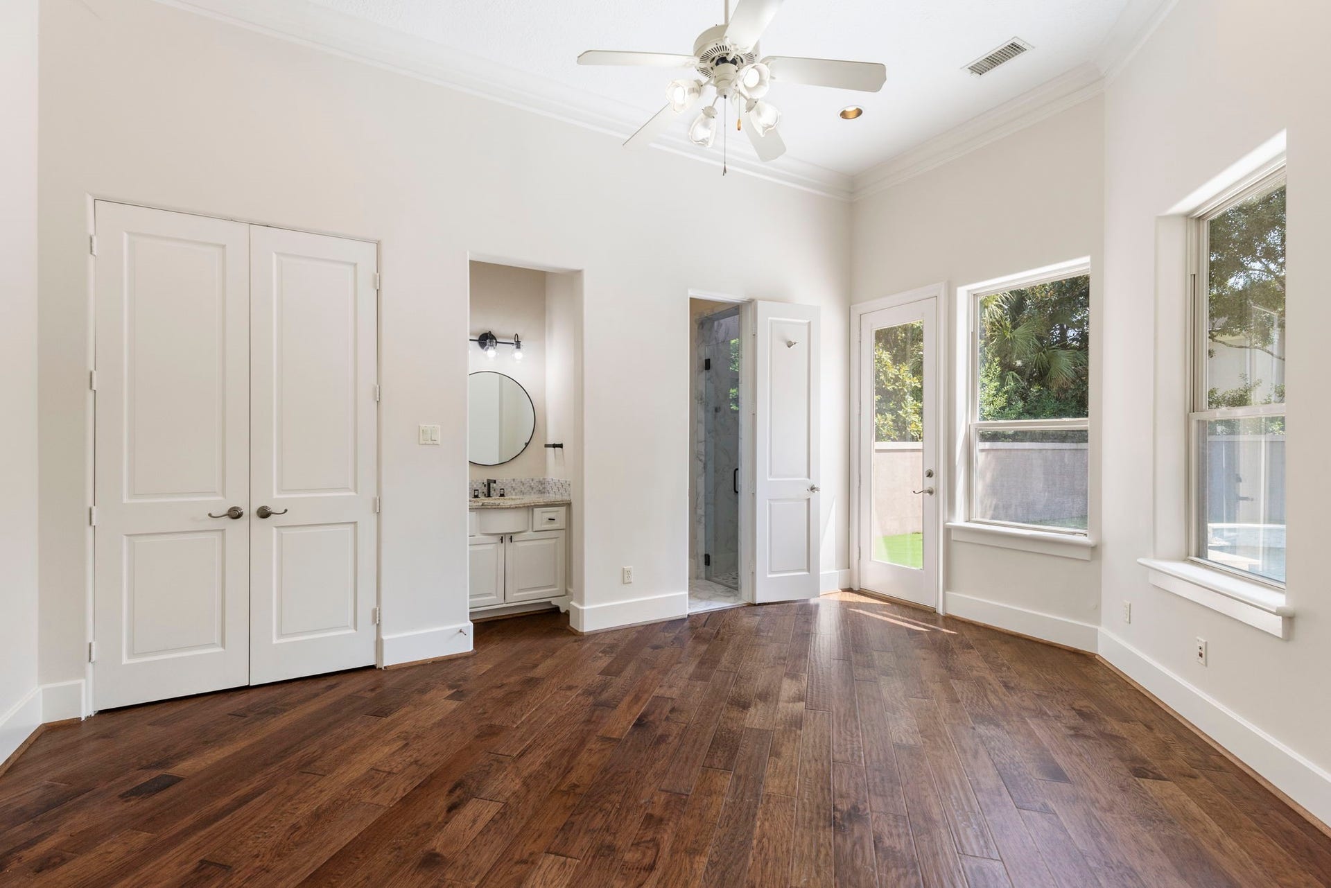 47 Hunnewell Way, The Woodlands, TX 77382 A first-floor guest suite offers hardwood flooring, a private ensuite bath with walk-in shower, & private access to the to the backyard.
