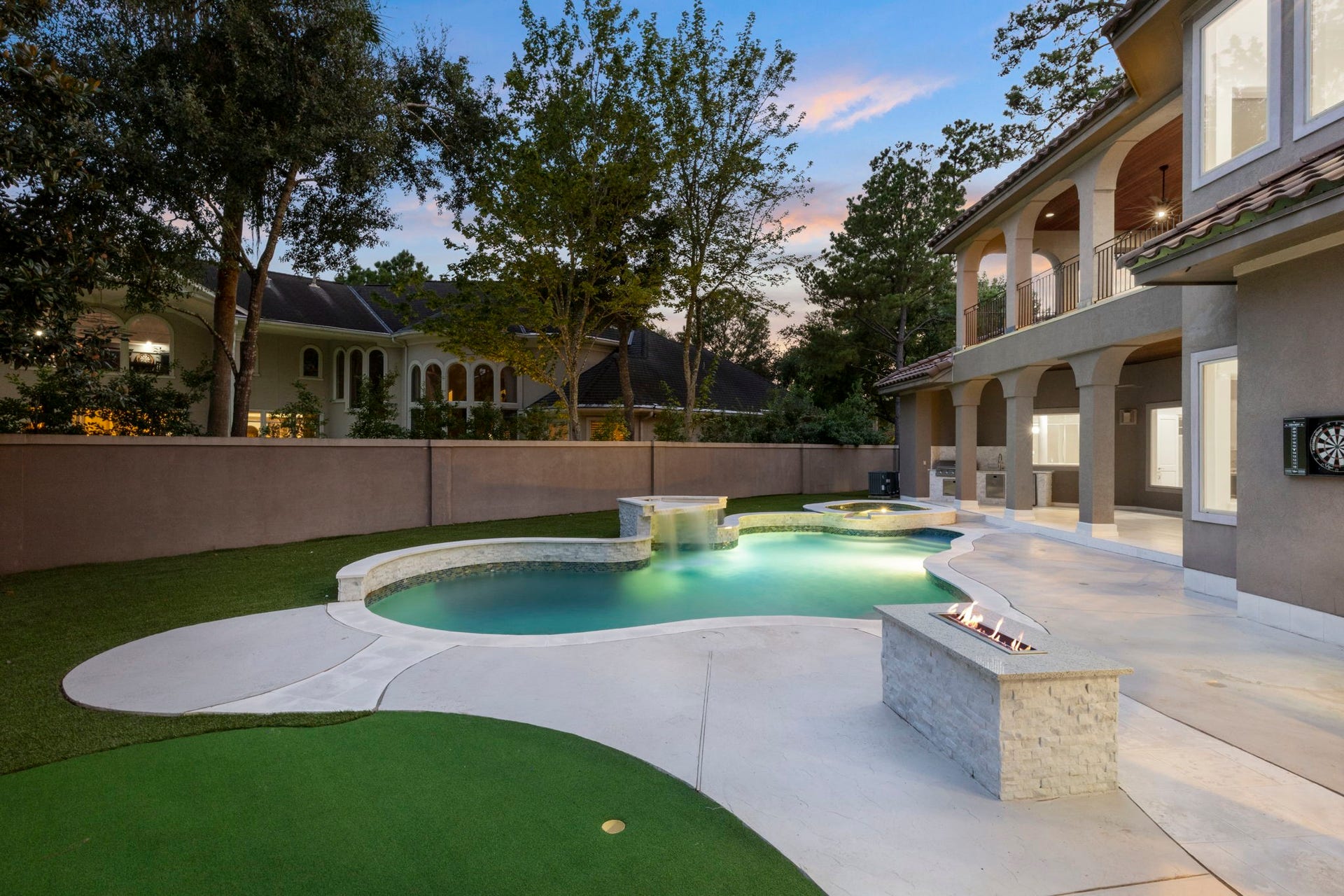 47 Hunnewell Way, The Woodlands, TX 77382 The backyard includes a dedicated putting green set within manicured turf, perfect for practicing your short game at home.