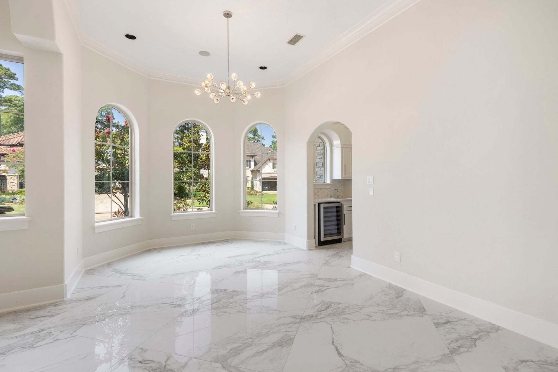 47 Hunnewell Way, The Woodlands, TX 77382 Formal dining with modernized chandelier has plenty of elbow room for hosting. A convenient butler's pantry and wine room are off to the right.