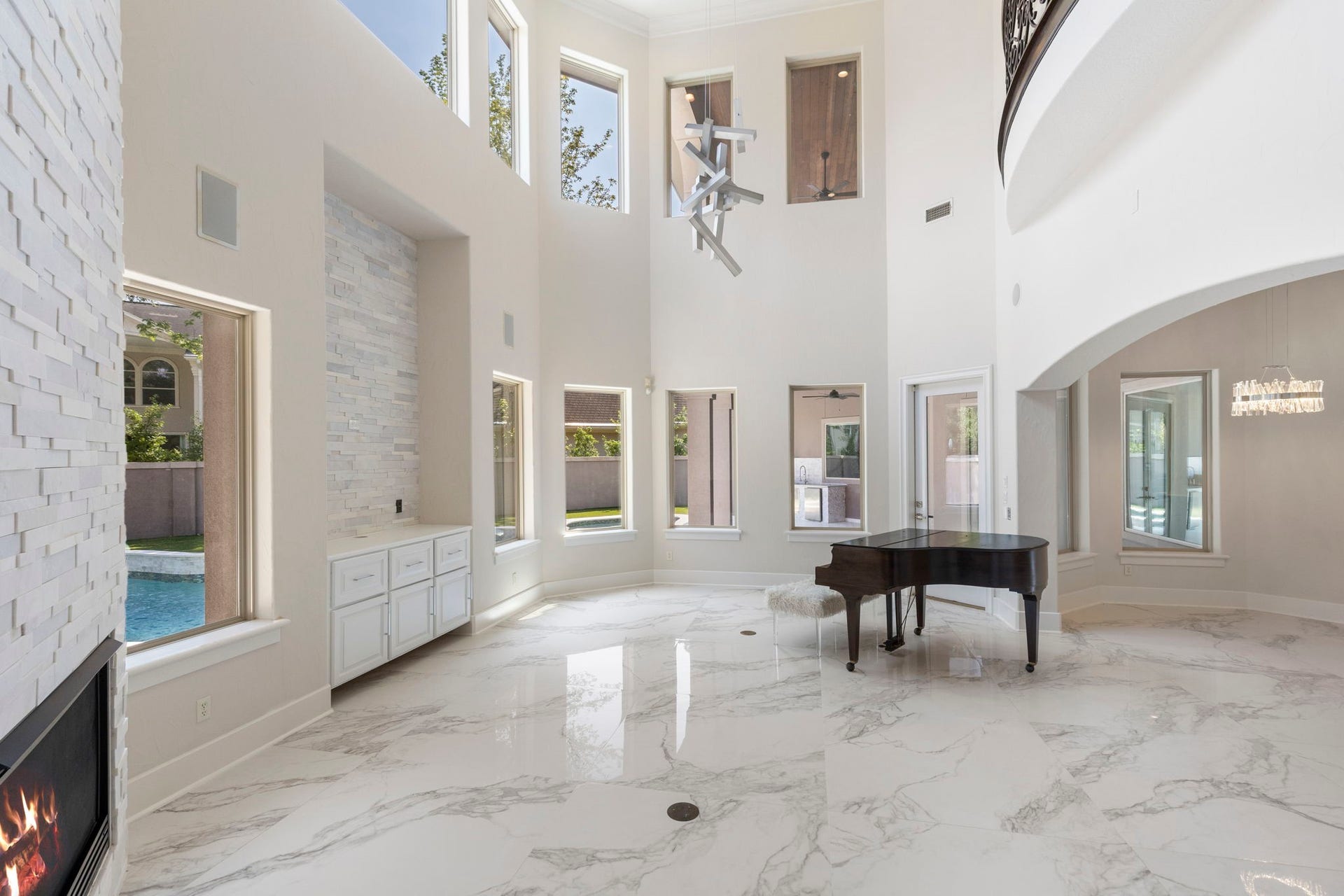 47 Hunnewell Way, The Woodlands, TX 77382 View from the kitchen into the family room, where soaring ceilings & a wall of windows fill the space with natural light.