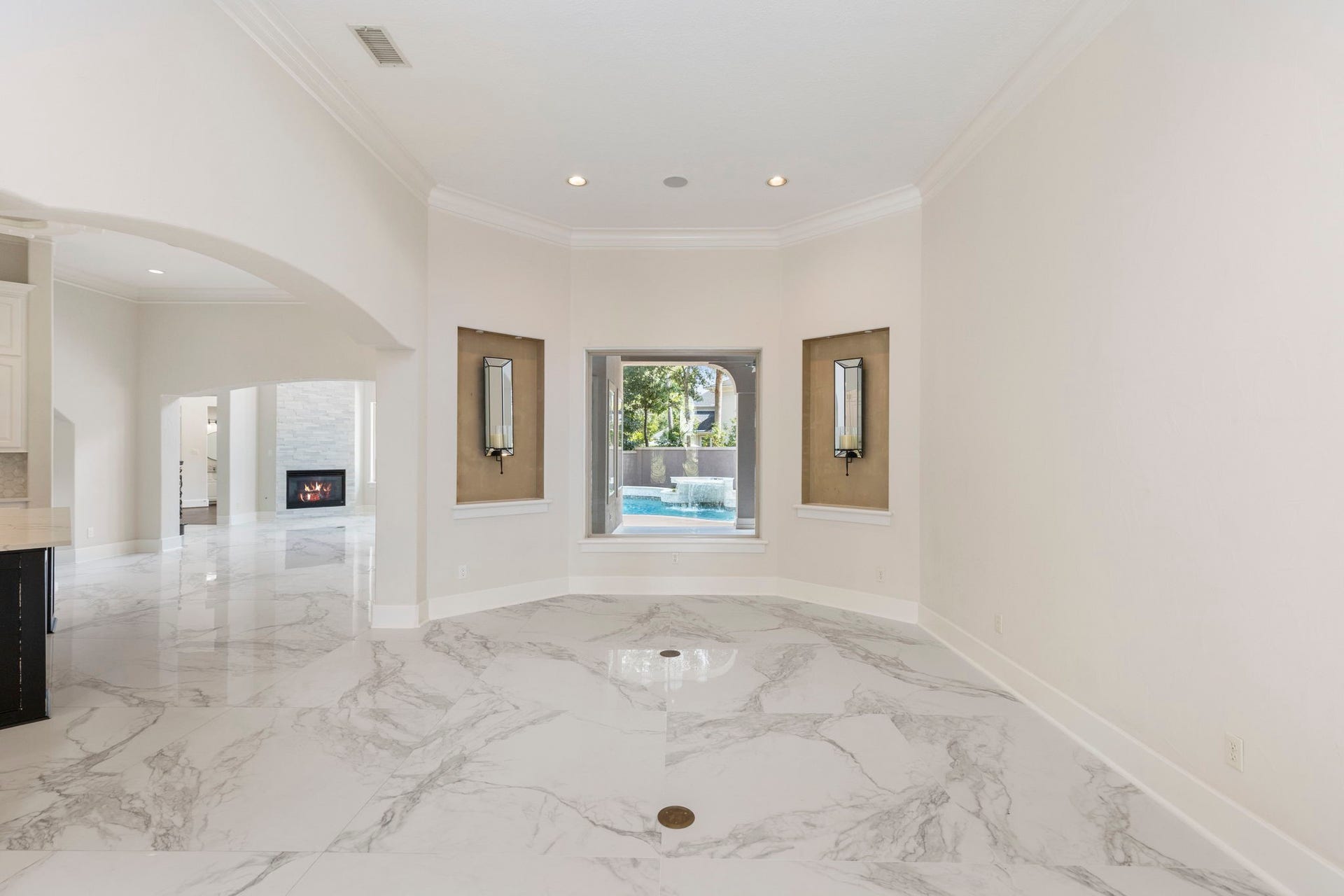 47 Hunnewell Way, The Woodlands, TX 77382 The formal living room centers on a picture window overlooking the pool & water feature, creating a bright conversational area ideal for entertaining guests.