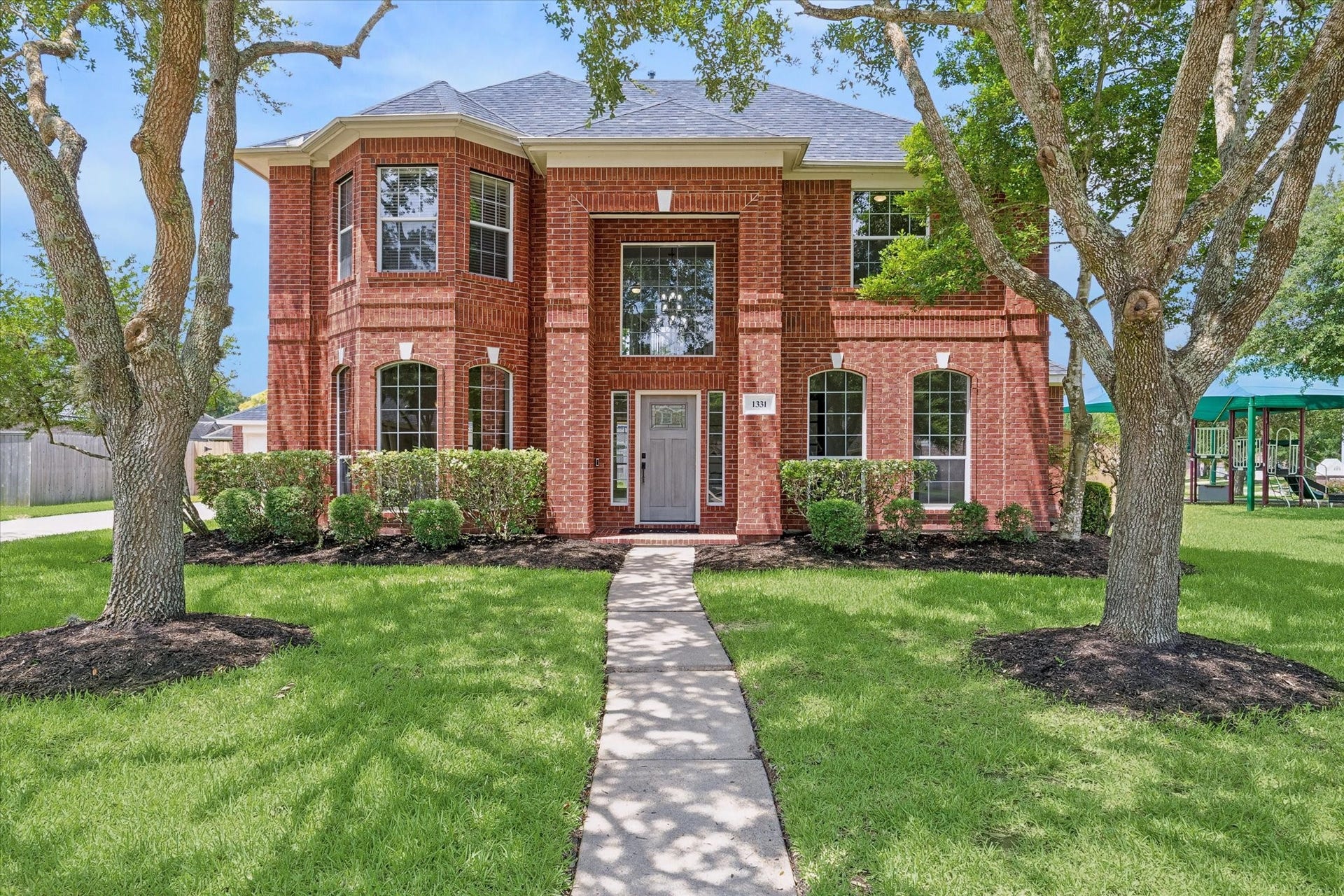 1331 SHADY BEND DRIVE, Sugar Land, TX 77479 A stately brick faade, mature oak trees, and professional landscaping create exceptional curb appeal.
