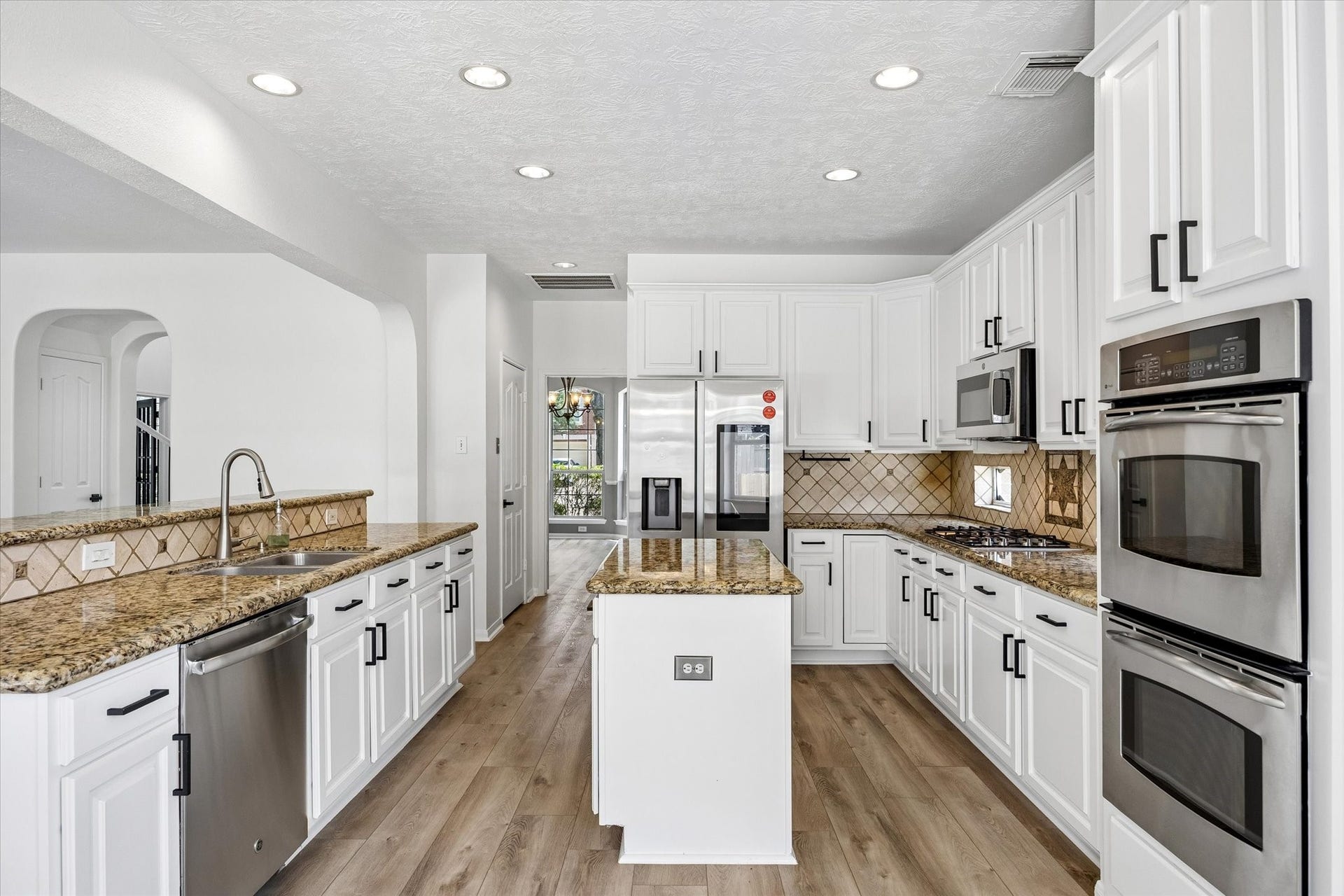1331 SHADY BEND DRIVE, Sugar Land, TX 77479 The remodeled kitchen showcases granite countertops, abundant cabinetry, stainless steel appliances, and a center island.
