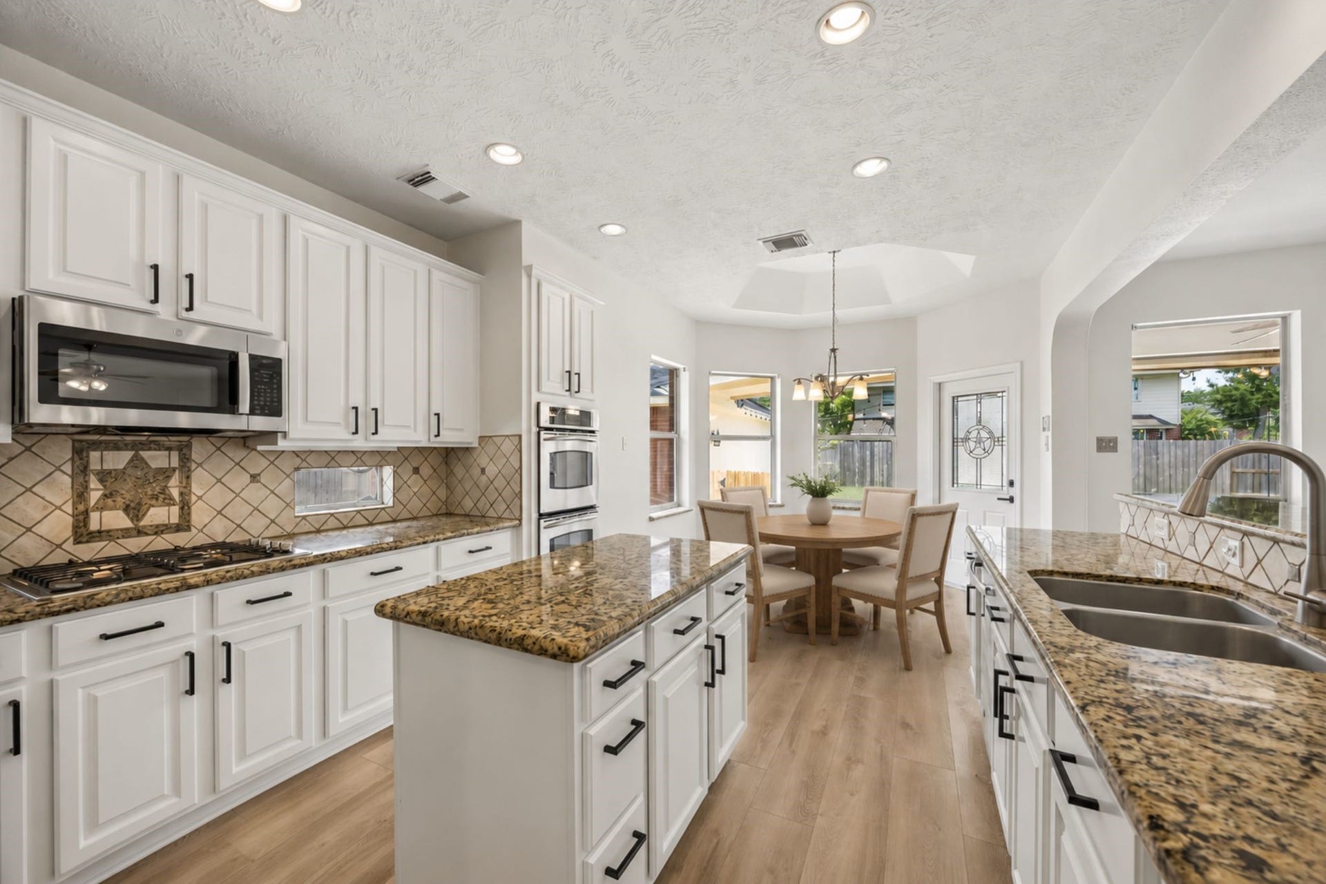 1331 SHADY BEND DRIVE, Sugar Land, TX 77479 Another view of the kitchen highlights the generous prep space, gas cooktop, double ovens, and open layout.