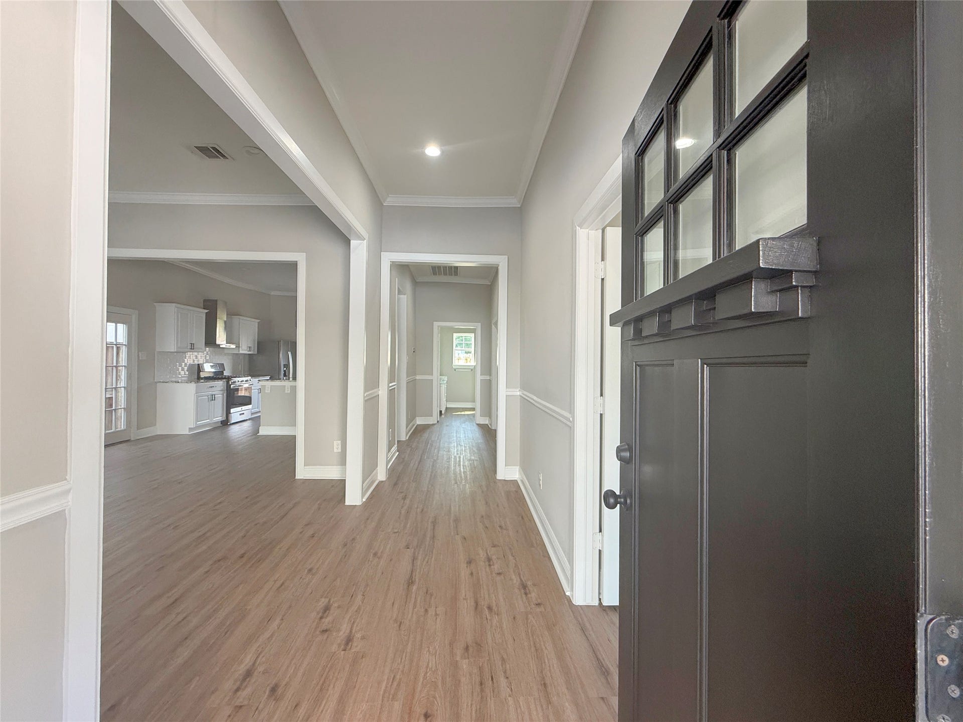 1517 COLORADO Street, Houston, TX 77007 Welcoming foyer featuring NEW flooring, crown molding, chair rail accents, and recessed lighting, with an open view into the kitchen and adjoining living areas.