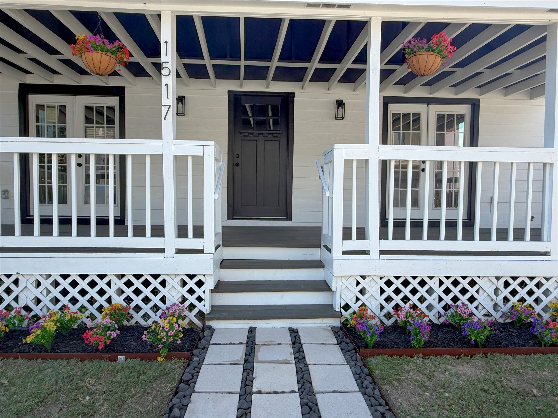 1517 COLORADO Street, Houston, TX 77007 Centrally positioned entry steps lead to a distinctive front door, flanked by French doors on both sides. A decorative paver walkway completes the welcoming entrance.