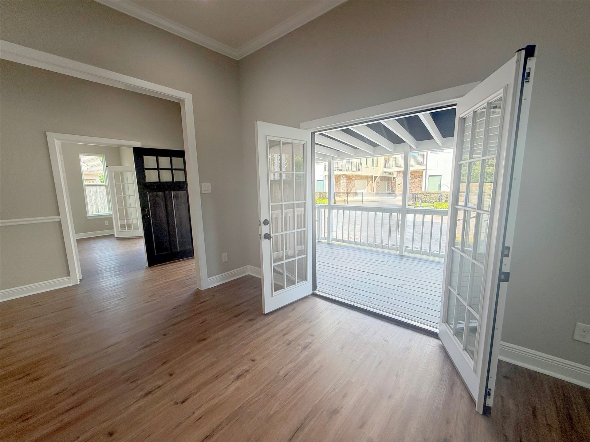 1517 COLORADO Street, Houston, TX 77007 Wide-open French doors beautifully frame the covered porch, extending the living area's appeal beyond the interior and creating an ideal setting for indoor-outdoor entertaining.