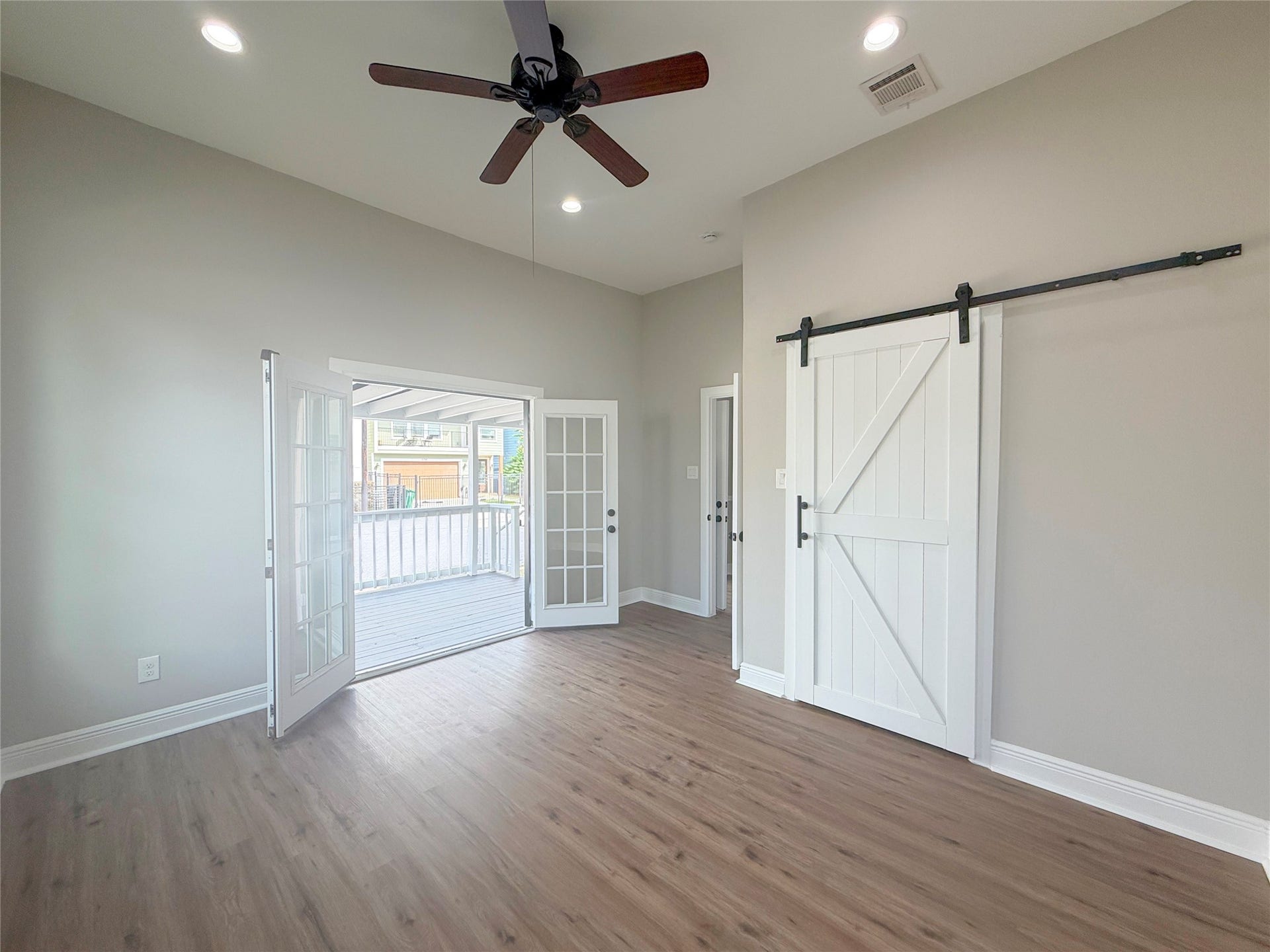 1517 COLORADO Street, Houston, TX 77007 Beautiful French doors open directly onto the expansive covered front porch, inviting natural light into this charming bedroom. High ceilings and a sliding barn door closet complete the space.