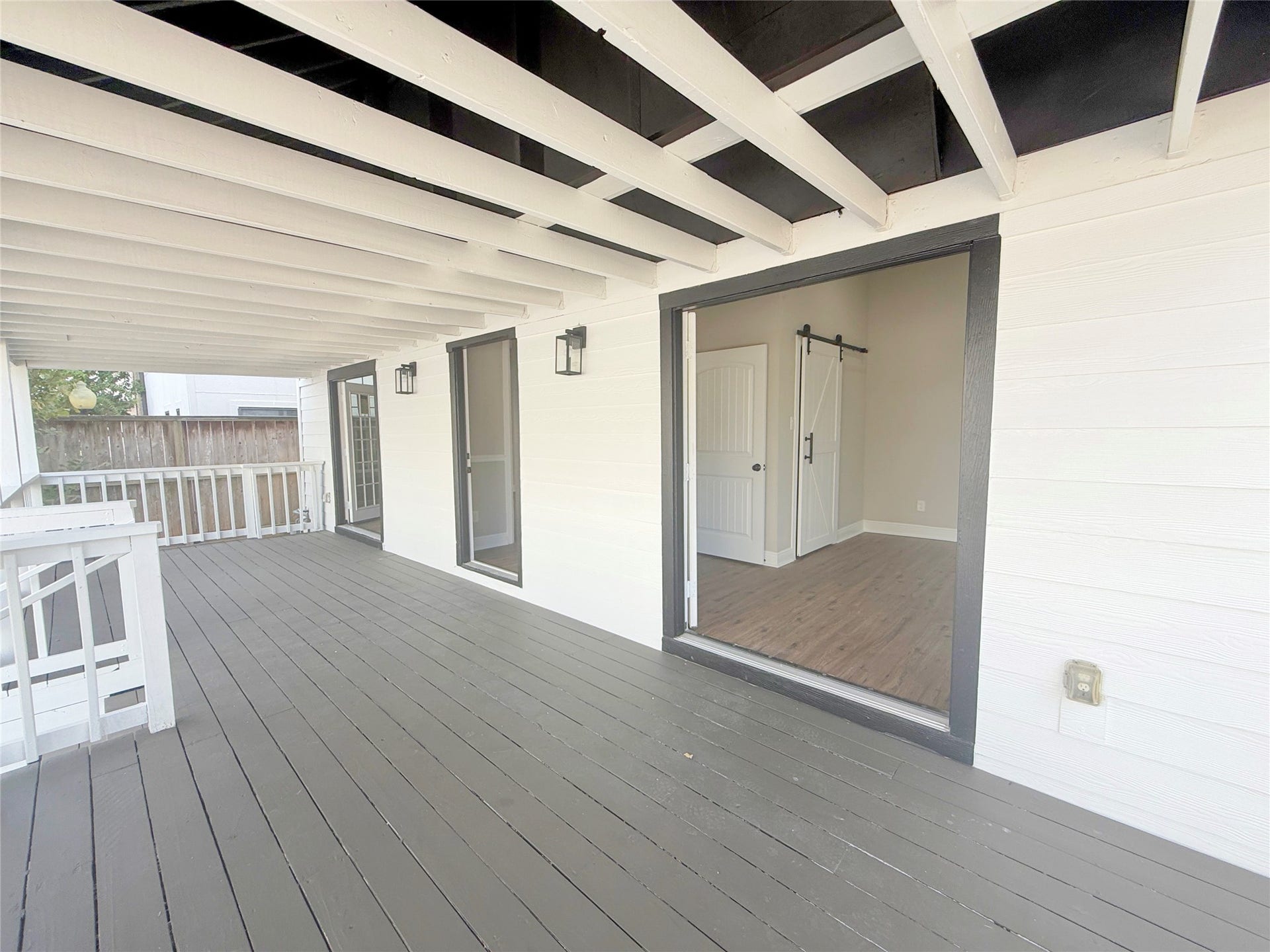 1517 COLORADO Street, Houston, TX 77007 Another perspective reveals the porch's impressive length and direct access to the secondary bedroom through French doors. The covered design and classic railing add architectural character to this inviting outdoor retreat.