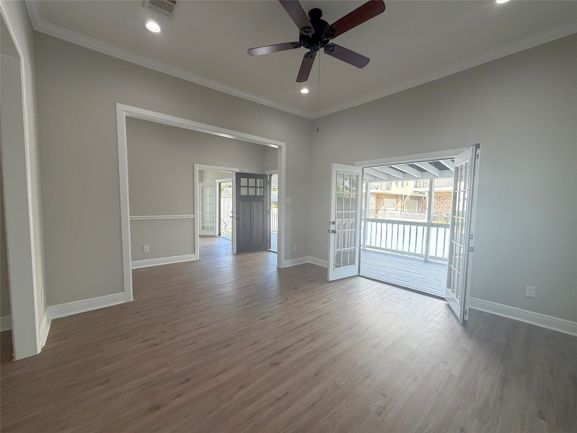 1517 COLORADO Street, Houston, TX 77007 The inviting living room features high ceilings, recessed lighting, and an open connection to the adjoining living spaces. French doors create an impressive transition to the home's spacious covered front porch.