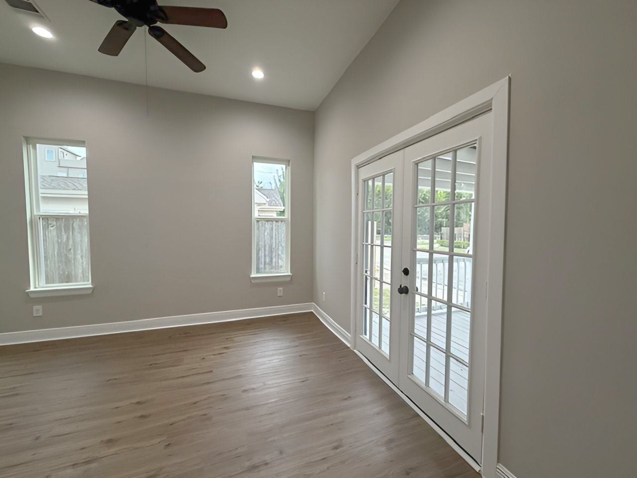 1517 COLORADO Street, Houston, TX 77007 Bright secondary bedroom offers high ceilings, recessed lighting, and French doors opening to the covered front porch, creating an inviting connection to the outdoors.