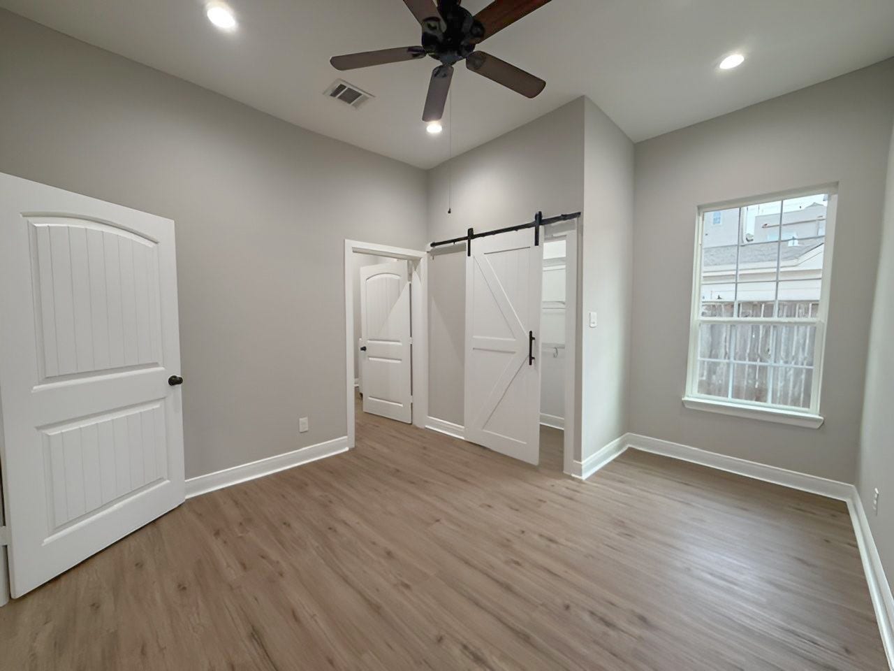 1517 COLORADO Street, Houston, TX 77007 Another perspective highlights the room's generous dimensions, natural lighting, and stylish barn door leading to the adjoining closet.