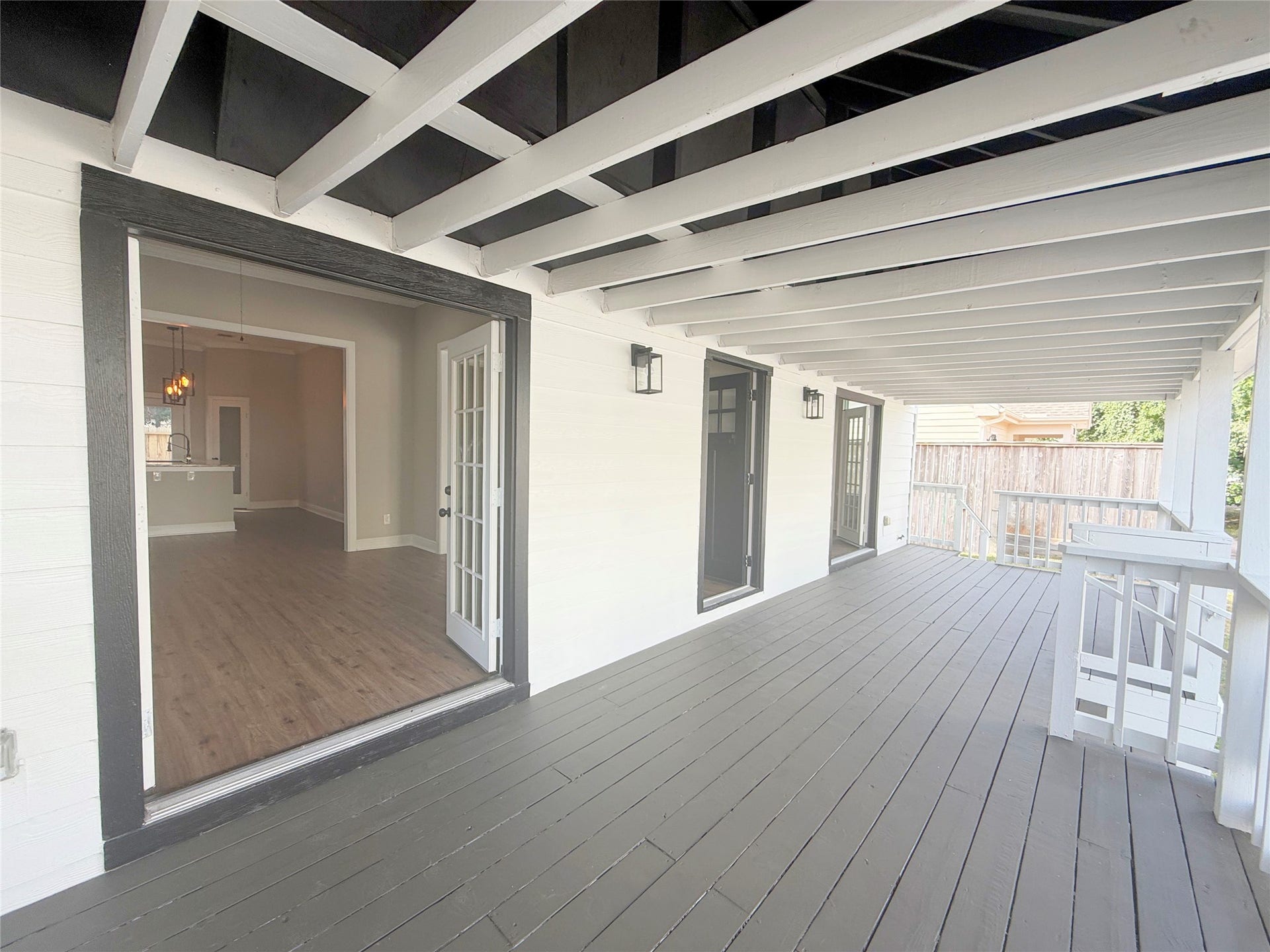 1517 COLORADO Street, Houston, TX 77007 This expansive covered porch showcases exposed ceiling beams, contrasting trim, and multiple entrances to the home. The generous layout provides wonderful possibilities for outdoor seating and relaxation.
