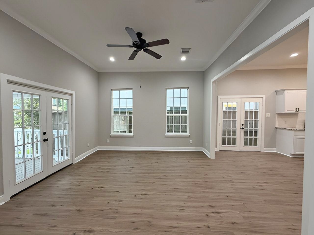 1517 COLORADO Street, Houston, TX 77007 Bright, open living space featuring updated wood-look flooring, NEW paint, recessed lighting, crown molding, and a ceiling fan offering flexibility for a variety of furniture arrangements.
