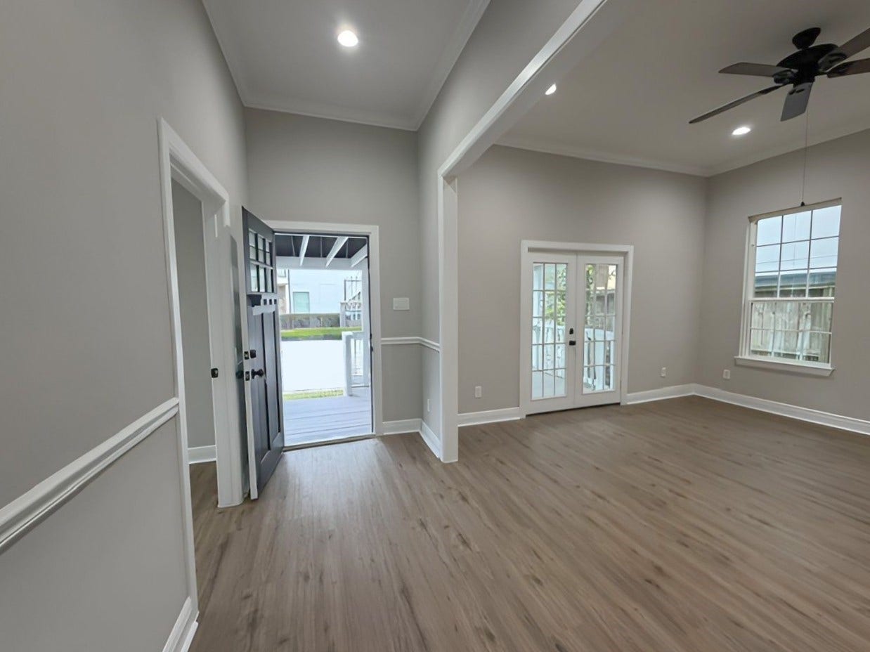 1517 COLORADO Street, Houston, TX 77007 Reverse perspective highlights the spacious living area, abundant natural light, and French doors opening onto the expansive covered front porch.