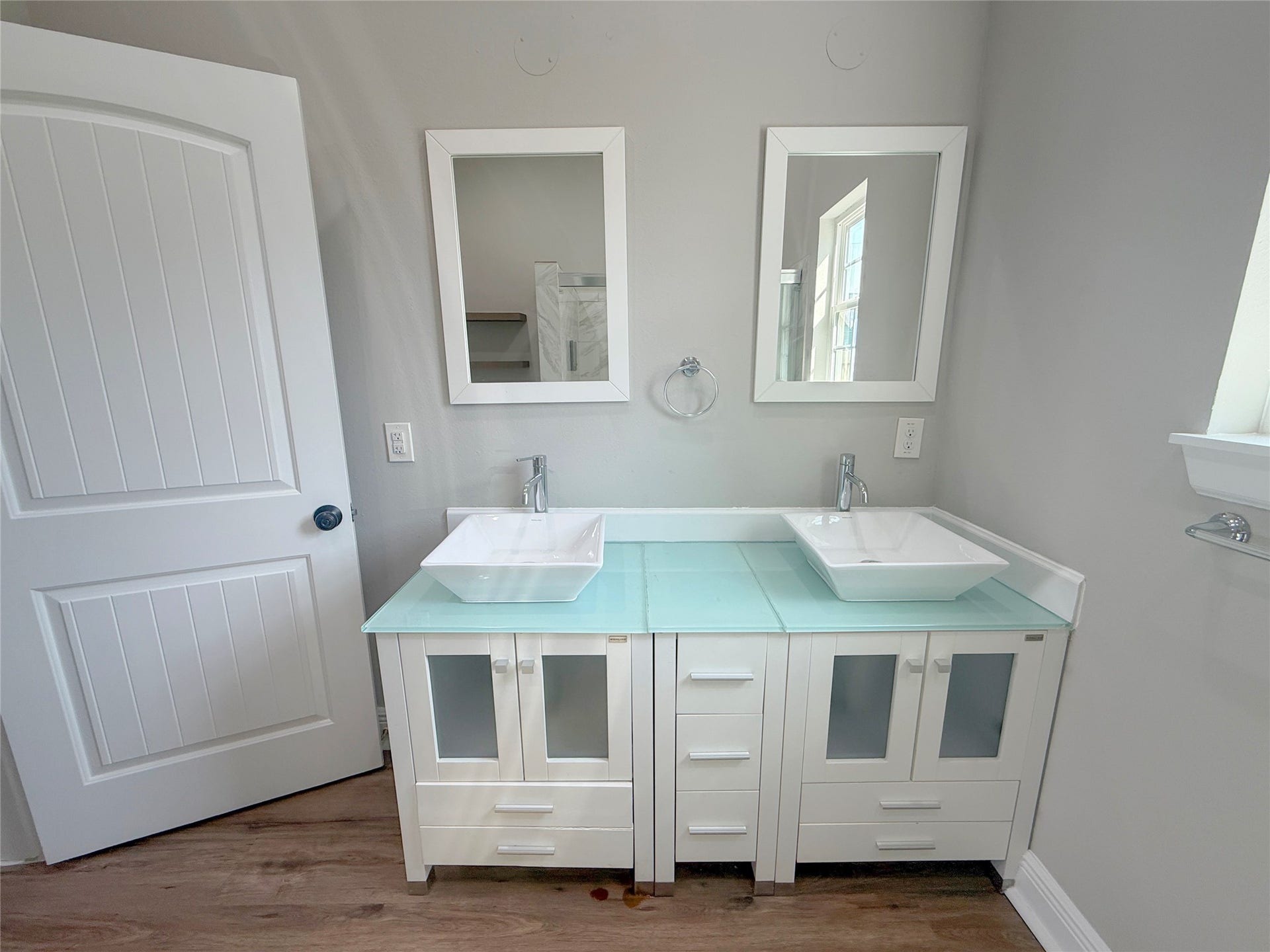 1517 COLORADO Street, Houston, TX 77007 Contemporary double-sink vanity features vessel sinks, sleek faucets, glass countertops, individual mirrors, and generous cabinet storage.