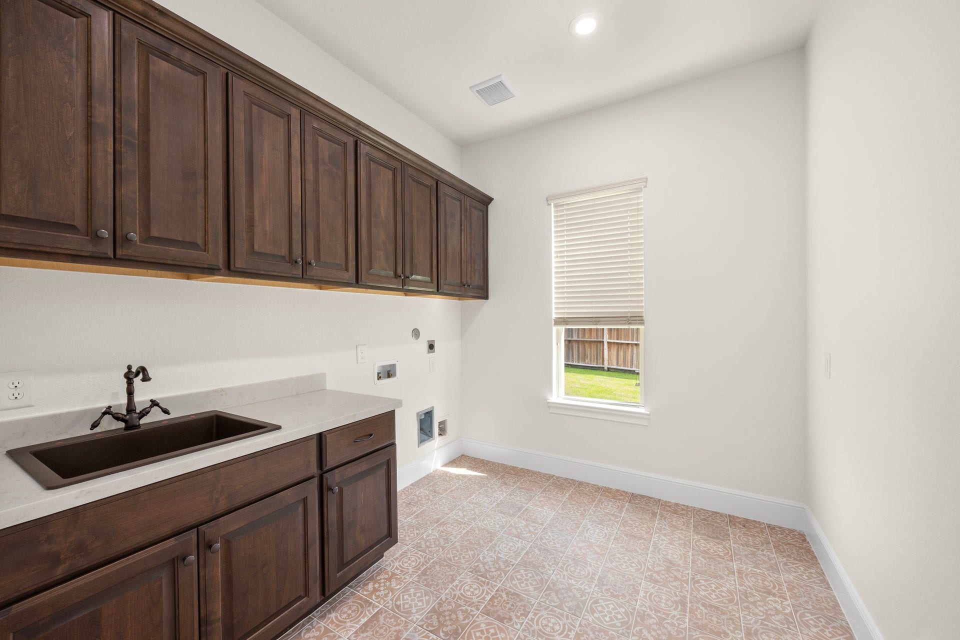 8551 Tombron Grove Road, Magnolia, TX 77354 The spacious laundry room is thoughtfully designed to combine everyday functionality with upscale style. Featuring abundant cabinetry and counterspace, this well organized utility room makes household task efficient. Beautiful custom tile flooring and ample storage with room for full sized appliances ensure the space is as practical as it is polished.