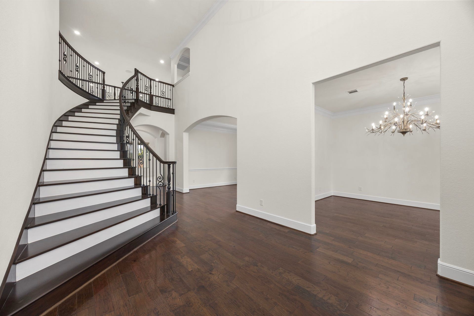 8551 Tombron Grove Road, Magnolia, TX 77354 Anchored by the home's stunning staircase, this elegant foyer showcases rich hardwood flooring, refined crown molding, and beautiful architectural detail.