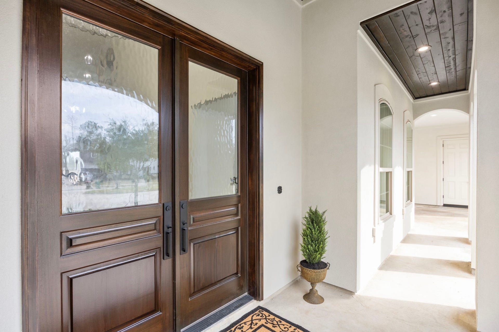 8551 Tombron Grove Road, Magnolia, TX 77354 The impressive solid wood double doors at the front entrance create a grand and welcoming first impression. Rich in texture and craftsmanship, these custom doors showcase beautiful natural wood grain and substantial construction that speaks to the homes quality.
