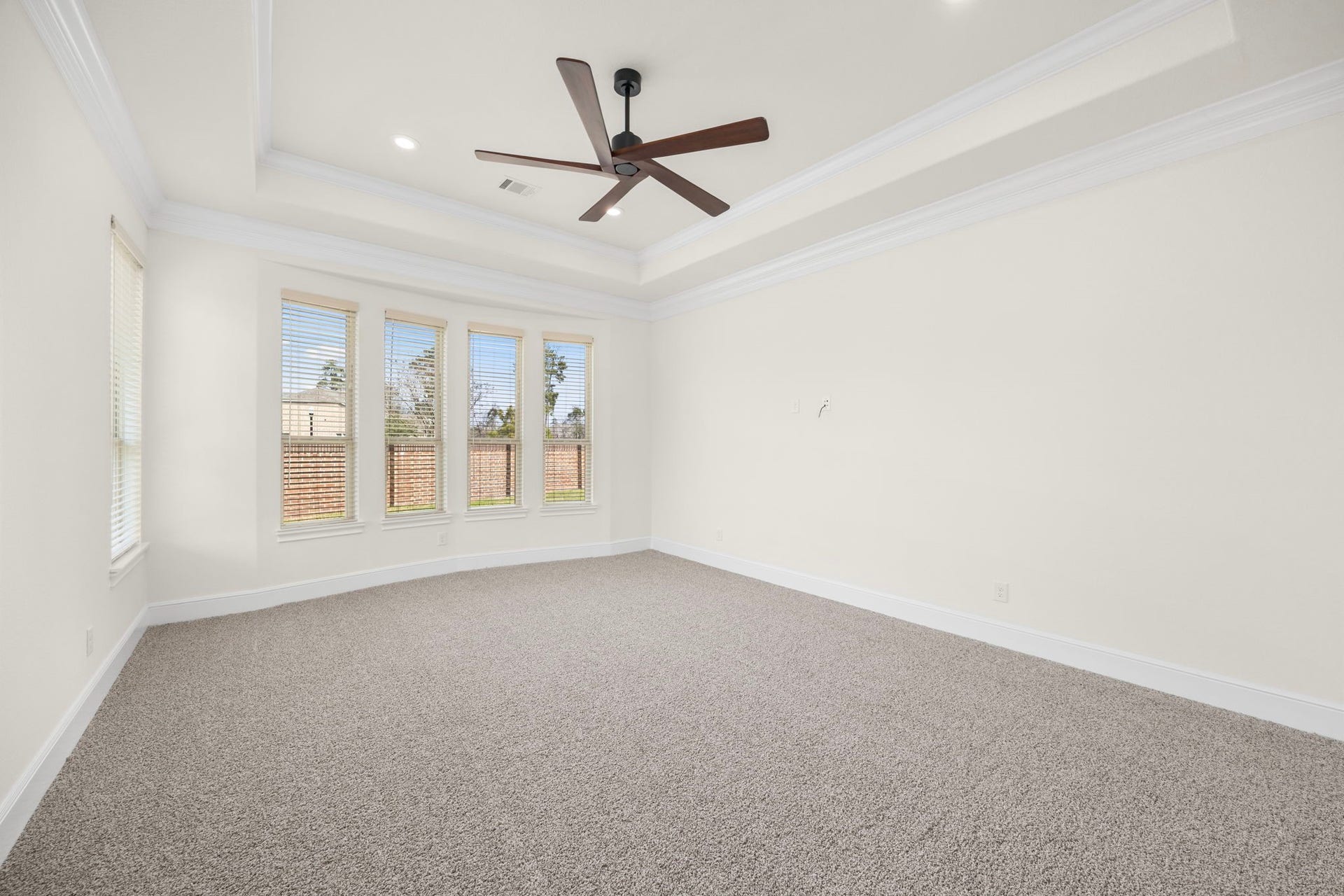 8551 Tombron Grove Road, Magnolia, TX 77354 The primary suite features soaring tray ceilings and elegant crown molding that create a serene upscale atmosphere.