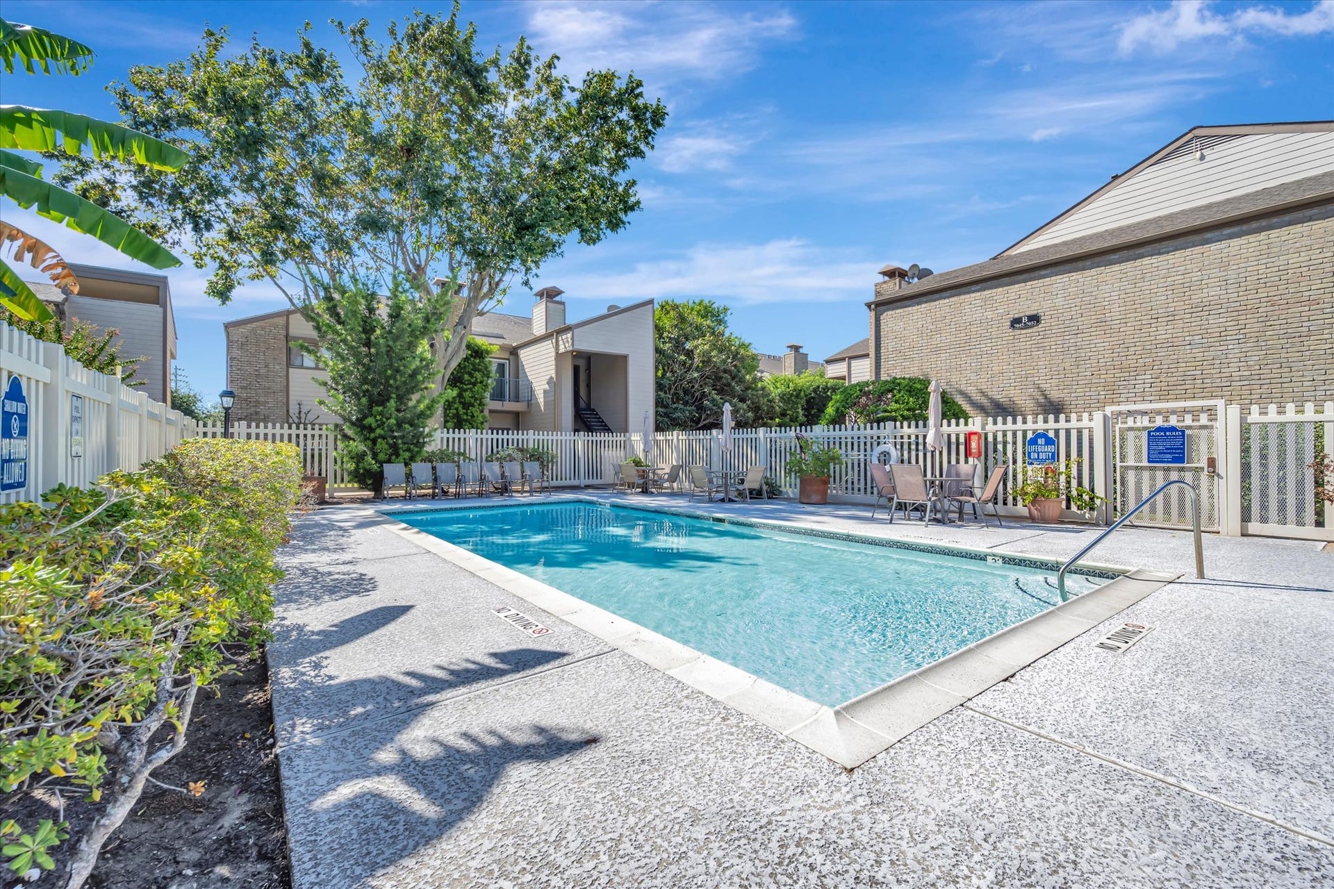 7071 N Holiday Drive, Galveston, TX 77550 Community swimming pool with a surrounding deck and landscaped setting.