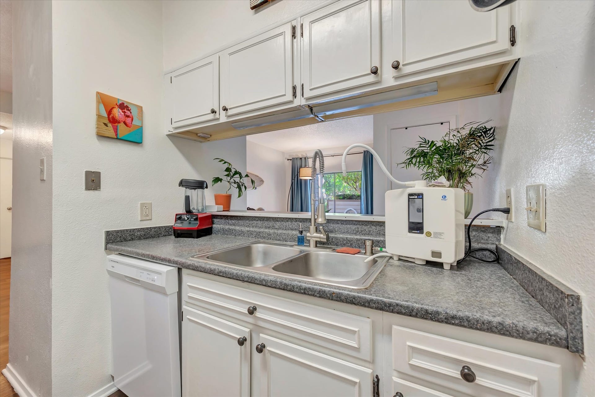 7071 N Holiday Drive, Galveston, TX 77550 Kitchen sink area with a dishwasher, window and countertop space on either side.