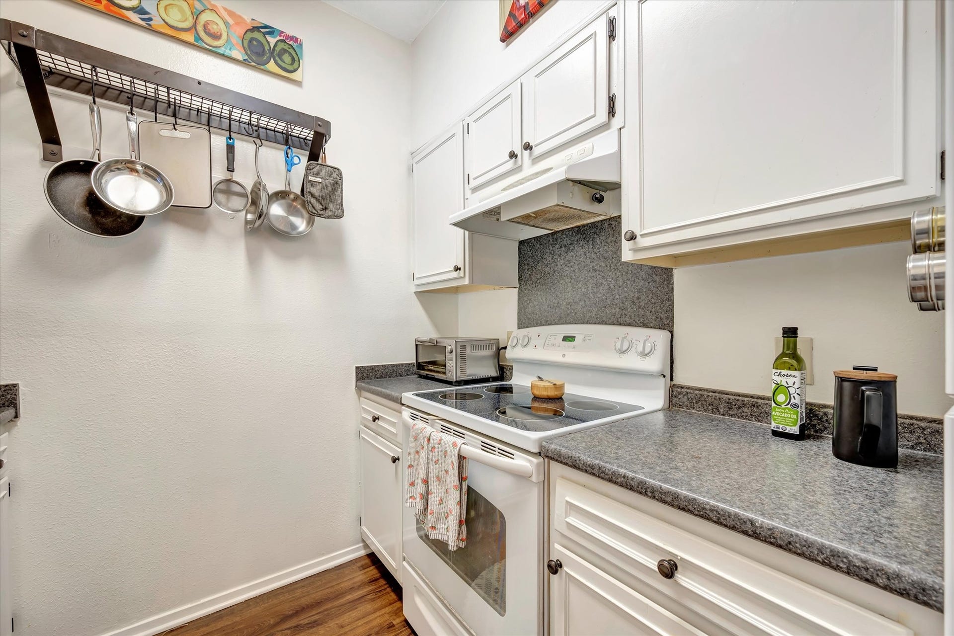 7071 N Holiday Drive, Galveston, TX 77550 Kitchen cooking area with a range, vent hood and surrounding cabinet storage.
