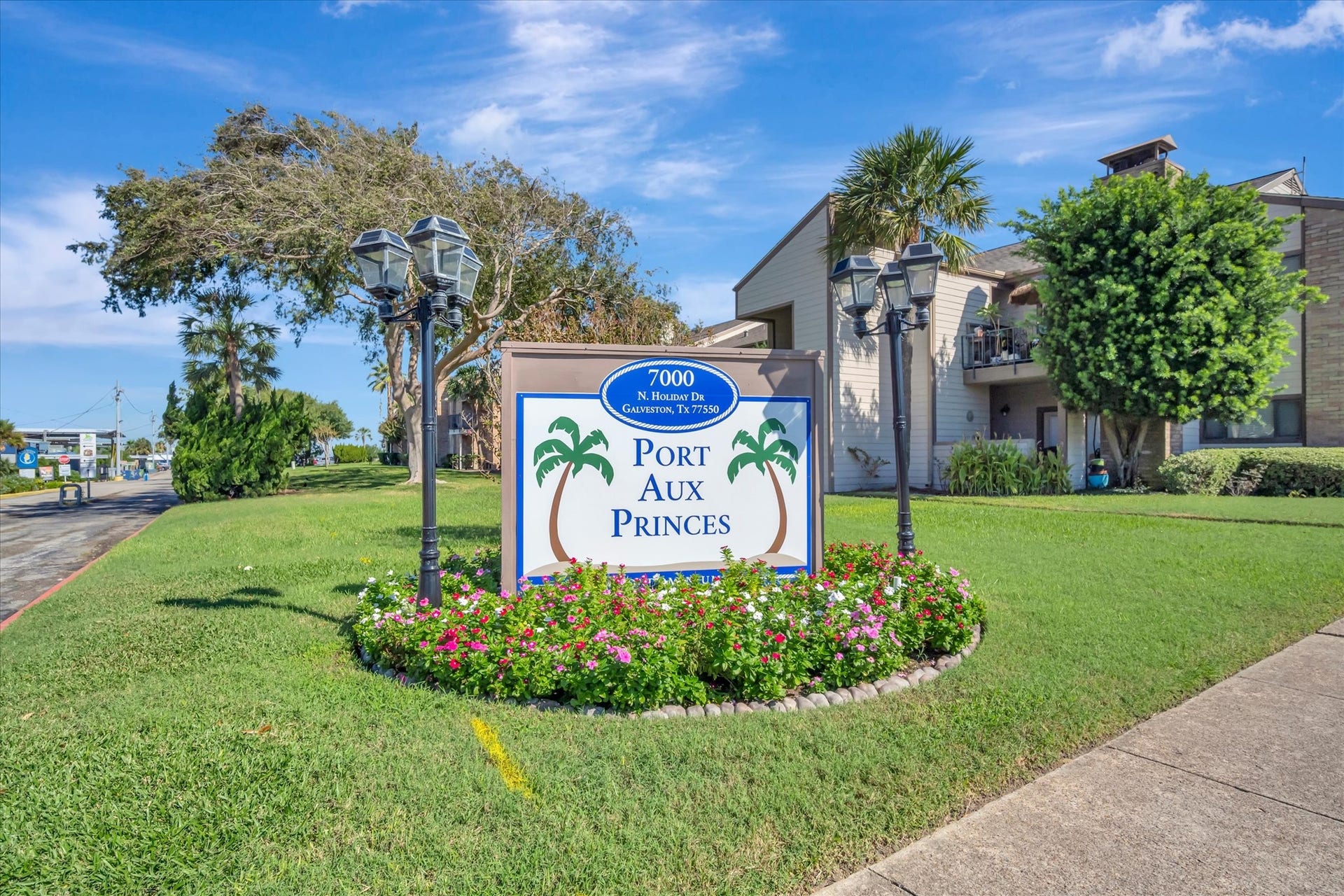7071 N Holiday Drive, Galveston, TX 77550 Landscaped community entrance with established trees and signage.