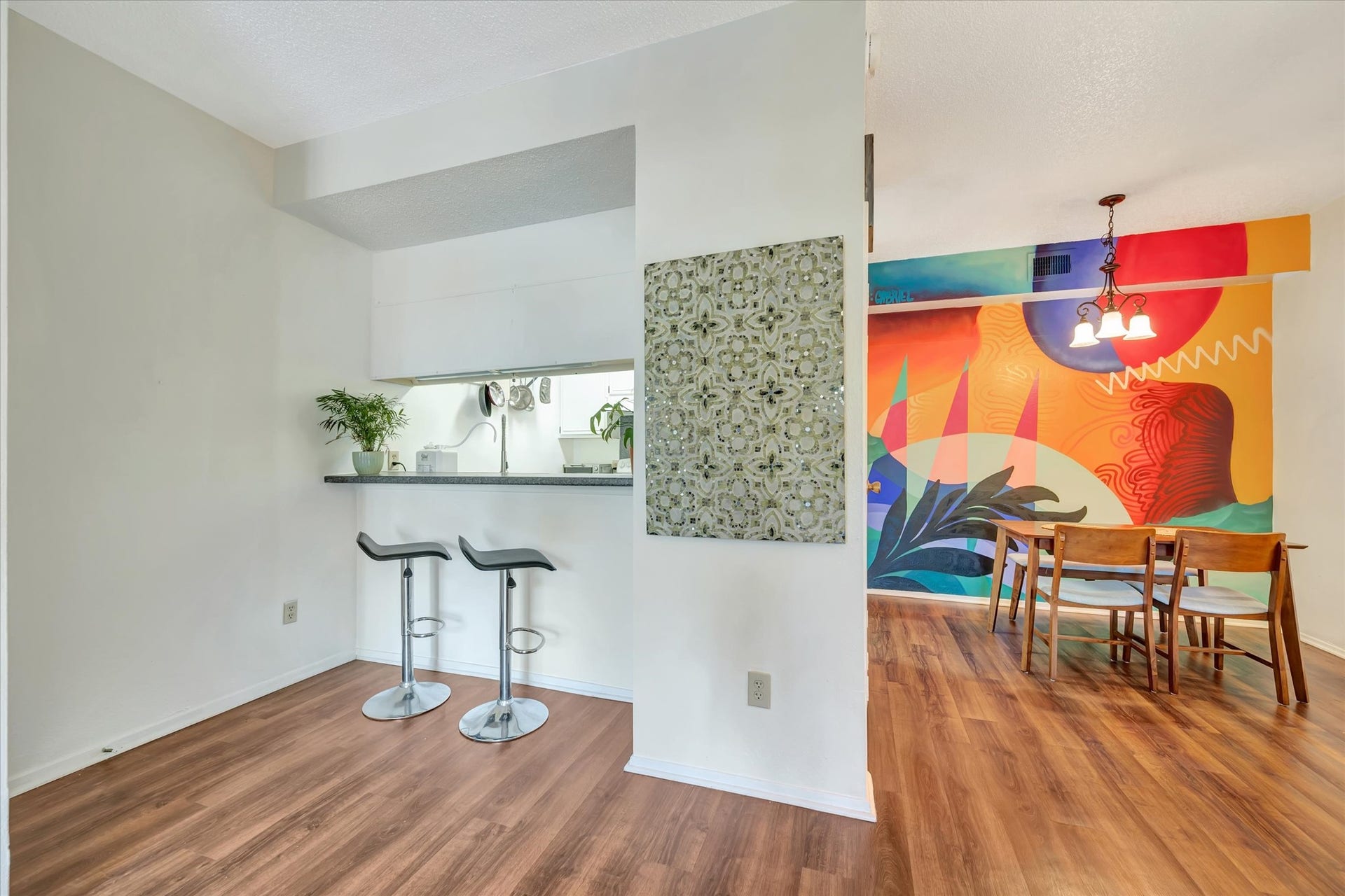 7071 N Holiday Drive, Galveston, TX 77550 Kitchen and dining area featuring a breakfast bar, wood-look flooring and a colorful custom mural.