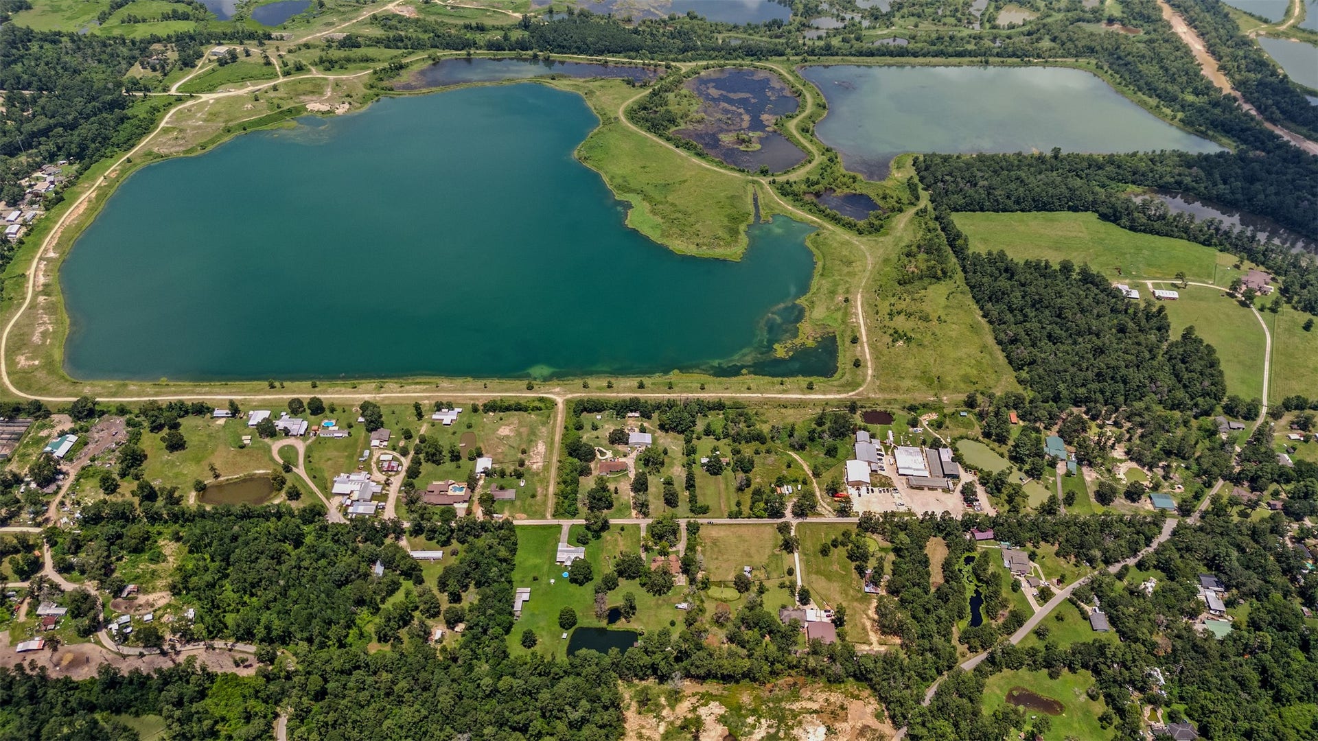 Aerial view of the surrounding properties with a lake close by.
