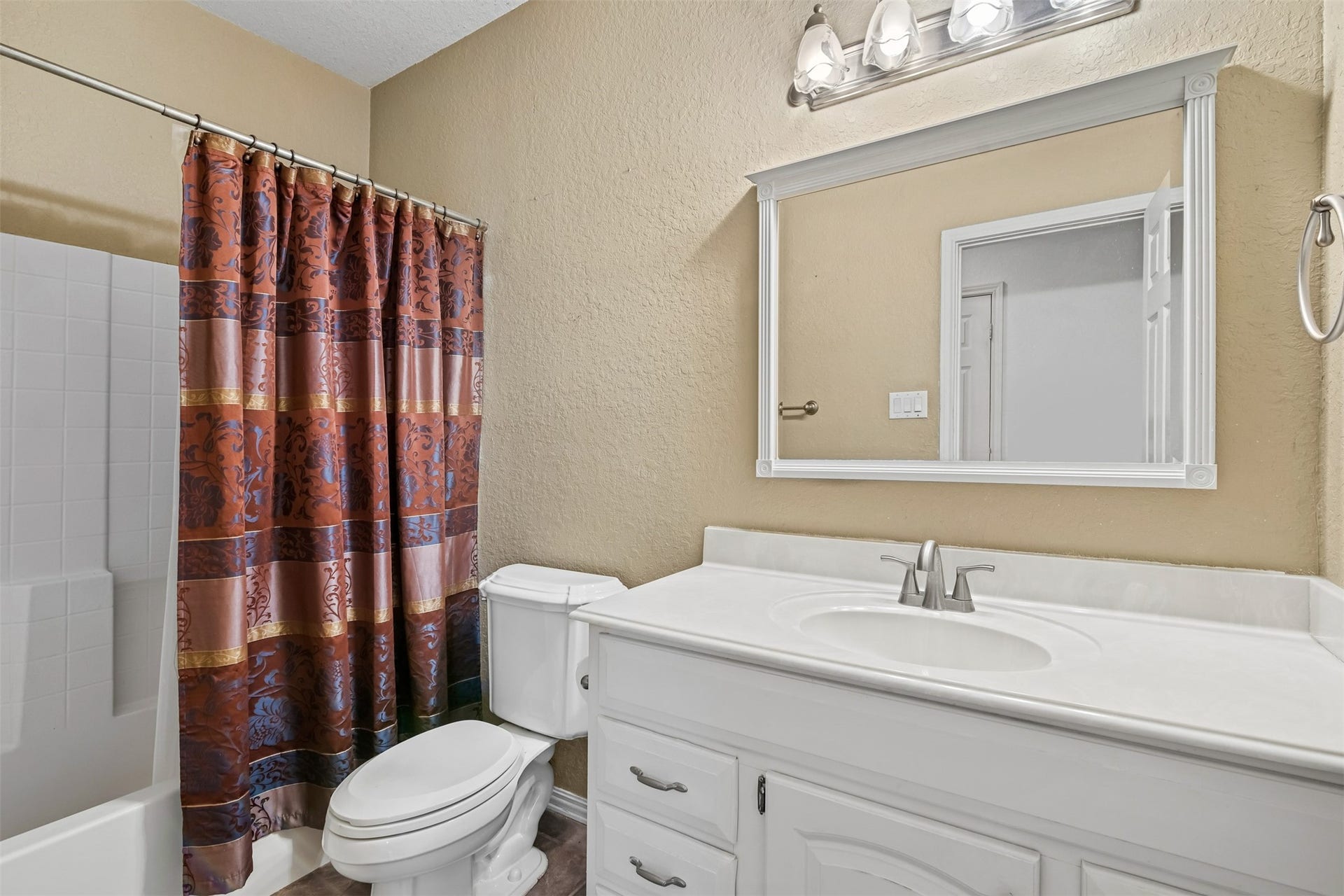 Secondary full bathroom with single sink vanity and tub/shower combo.
